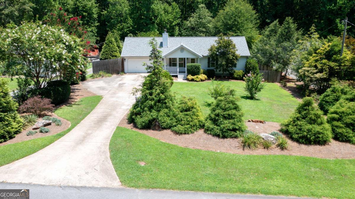 LOCATION LOCATION LOCATION - RECENTLY REMODELED BATHROOMS, ROOF AND HVAC UNDER 7 years old and OVERSIZED GARAGE add to the value you get with this home and NO HOA!!!! This beautifully maintained ranch in coveted Forsyth County Schools is ready for YOU!. Come enjoy coffee on your rocking chair front porch. Relax in front of the fireplace as you cozy up with your favorite movie. Enjoy those rainy days in your air conditioned sunroom with a good book and a cup of tea while you listen to the rain drops. Gardening and green thumbs welcome on this large lot that has an irrigation system to take care of all the watering for you! This road is a private street with no one driving down it unless you live there. This home is cozy, room to live and room to play. Come TOUR TODAY!