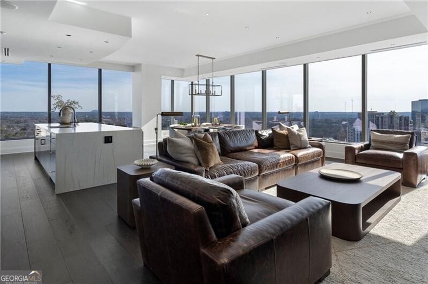 Located in Buckhead's prestigious Ritz Carlton Residences, this corner unit features stunning views of the Atlanta skyline, Midtown, Stone Mountain and the north GA mountains.  The open concept floorplan allows unobstructive views and delivers an immediate "wow" factor when you round the hall from the full, foyer entryway.  This condo is gracious in size offering 2 bedrooms, 2 full baths, 1 half bath & additional living space perfectly suited for a private office.  Meticulously maintained and renovated for immediate, move-in condition.   Within the last year the owners have beautifully updated many features: New and neutral paint throughout (walls, ceilings, doors, trim), Quartzite counters with waterfall island), custom millwork features in half bath, office, owner's suite w/ built-in cabinet and feature wall, stunning new light fixtures throughout each living space, a custom-designed feature wall in the living room with lighting and shelving.  Upon entrance, a true foyer with 10ft ceilings welcomes you.  The kitchen includes an oversized island, top-of-the-line appliances, full size wine cooler, full size drink cooler, coffee bar, cabinetry enclosed refrigerator, and ample island seating.  The kitchen, dining, and living space are the perfect setup for hosting family gathering and parties.  The owner's bath and secondary bath are fully marbled and include new grass cloth wall covering, light fixtures, and mirrors.  As with the main living spaces, both bedrooms offer spectacular views.  The ideal floorplan allows for privacy from the living spaces to the bedrooms.  The balcony provides privacy, a view of Stone Mountain, Captial City Golf Course, and beautiful, wooded, long range views.  This unit includes 2 parking spaces and 3 storage spaces (one is climate controlled). Ritz Carlton Residences offer a full, luxury experience including: 24-hour concierge, valet parking, on-site management and porter services.  The residences include world-class amenities: year-round heated pool and hot tub overlooking Atlanta, fitness studio, catering kitchens, movie room, grilling stations, outdoor TVs, fireplace, and gathering spaces, two level club room, private office space, dog park, and 2 guest suites.  The Ritz Carlton Residences are walk-able to fine dining, entertainment, and shopping at Phipps Plaza.  Close by country clubs include Capital City Club & Cherokee Country Club.  This community of private, luxury residences offer the discerning buyer an experience like none other in Atlanta.  Welcome home.
