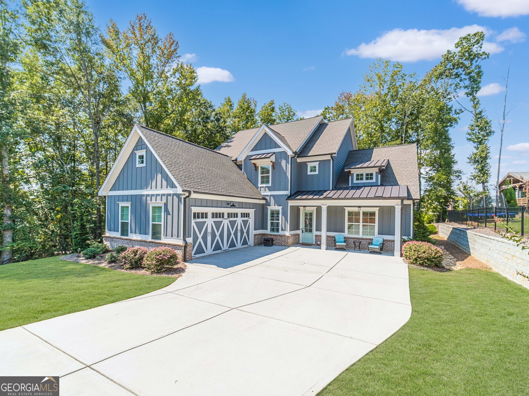 You will love this stunning Hillgrove Homes resale in the sought-after Traditions of Braselton community. This home is beautiful from the front door to the back yard. The 8-foot entry doors that are mirrored in the formal living/dining room create such a statement. 10-foot ceilings on the main level, and 9-foot ceilings upstairs. That front flex room would make a great formal dining room, home office, or music room, and you will love the custom floor-to-ceiling wall trim. The great room, kitchen, and farmhouse-sized breakfast room create the perfect entertaining space. The kitchen has double ovens, microwave, dishwasher, gas cooktop, venthood, large island, tons of white cabinets, and granite countertops. The main living spaces feature durable Revwood Flooring. The primary bedroom on the main is spacious with high trey ceilings, and a custom board and batten wall treatment behind the bed. The primary bath is beautiful, with double vanities with granite tops, beautiful tile floors, and oversized walk-in shower that the builder called a Super Shower. Huge walk-in closet. Mud room is across from the oversized laundry, with ample cabinets and a sink. The walk-in pantry is perfection. Butler's pantry with a beverage fridge, prep sink, cabinets and shelves would make a perfect coffee bar. 3 bedrooms and 2 full baths upstairs, plus an extra-large bonus room that is currently a billiards room. The covered back porch with gas fireplace is the perfect place for fall Saturdays watching football. The yard is wooded, with plenty of privacy, and the sellers just invested a good amount of money landscaping the yard with new plantings. This large home is a perfect place to move to in this sought-after golf community. Swim/Tennis/Pickleball and Playgrounds in the community.