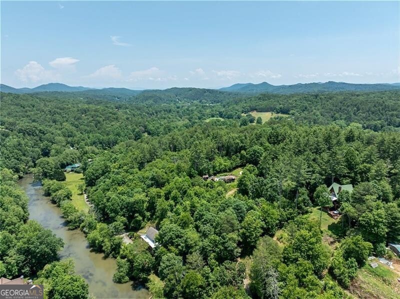 Unlimited potential to grow a business, develop, or enjoy as a secluded family retreat - 17+- acres in Blue Ridge with RARE Toccoa River frontage and access (the largest on the market), AND mountain terrain, trails and views. Currently operated as Toccoa House Properties for cabin rentals and special events, with six cabins, an event space, community swimming pool, regulation pickleball court, four cornhole courts, a nine-goal disc golf course, horseshoe pit, and playset, plus priceless natural amenities including hiking trails and fishing access. The property feels secluded and remote but is close to downtown Blue Ridge, which has become a hot real estate market and destination for shopping, dining, craft breweries, and entertainment. The property feels secluded and remote but is close to downtown Blue Ridge, which has become a hot real estate market and destination for shopping, dining, craft breweries, and entertainment - and a quick drive to popular Old Toccoa Farm semi-private golf club. Relying solely on word-of-mouth marketing, the rental business has been successful, and is primed for the next operator or developer, with mostly untapped potential to become the epitome of Blue Ridge destinations. Schedule a call and tour to discuss developing the riverfront, increasing river accessibility for fishing and paddle launch, upgrading vehicular access for existing walking trails. The existing cabins are currently in the rental program, and could continue to be used as-is or polished up for higher rates. Don't miss the opportunity for a rare piece of land in the mountains, with Toccoa River frontage, and untapped potential for a business, development, or family retreat.