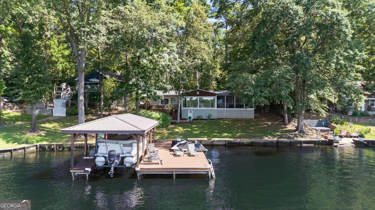 Sinclair lakefront cutie with huge lakefront appeal! HUGE PICTURE WINDOWS THAT BRING THE LAKE STRAIGHT TO YOU! Sits down close to the water for the full lake experience! One level home with 3 bedrooms, 2 baths. Updated bright kitchen - open floorplan with centrally placed fireplace that oozes charm! Fabulous lakeside screened porch is the icing on the cake! Fully furnished and ready to enjoy. Newer roof and water heater. HVAC approx 5 years old. Single boat house DEEP WATER. Lease strip ($100/year). List Date: 7/12/2025 Expire Date: 12/31/2025