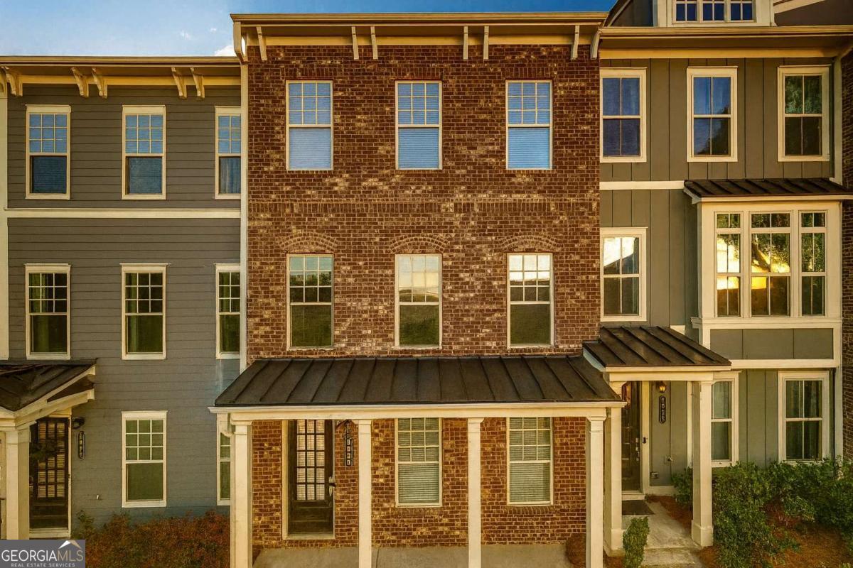 Welcome to a residence where timeless charm meets modern sophistication. Perfectly positioned just moments from the vibrant Historic Downtown Norcross and with effortless access to I-85 via Jimmy Carter Blvd, this move-in ready luxury townhome offers the perfect blend of elegance, comfort, and convenience. Step inside to discover a beautifully crafted home featuring 4 spacious bedrooms, 3.5 spa-inspired bathrooms, and a 2-car garage, thoughtfully designed for both everyday living and elegant entertaining. The terrace level offers a private guest suite with a full bath, ideal for in-laws, visitors, or a serene home office. On the main level, an open-concept living space invites warmth and connection, anchored by a cozy fireplace in the family room and seamlessly flowing into a designer kitchen with granite countertops, premium stainless steel appliances, and abundant cabinetry. A bright dining area extends to a charming deck, perfect for morning coffee, weekend brunches, or sunset unwinding. Upstairs, the owner's suite serves as a peaceful retreat with a spa-like bath, walk-in tiled shower, and built-in bench for added comfort. Two additional bedrooms share a stylishly appointed bathroom, while a convenient laundry room is smartly situated nearby for everyday ease. This exquisite townhome embodies the best of modern living in a setting rich with character and walkable charm. Don't miss this exceptional opportunity to call Norcross home.