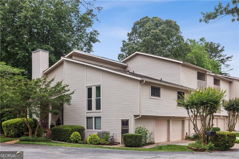 Welcome to this spacious and versatile end-unit townhome in the desirable Indian Hills Country Club community of East Cobb. Featuring a unique half-level split floor plan, this home offers the feel of a single-family residence with just a few steps between levels-providing both comfort and convenience. A dramatic two-story foyer welcomes you in, with access to the main living area or down to a cozy family room with a fireplace. Adjacent to the family room is an open flexible space next to a full bathroom-could be enclosed to create a guest suite, home office, or fourth bedroom. The lower level also opens to a large screened-in porch, ideal for relaxing or entertaining year-round. The main level includes a two-story dining room and an eat-in kitchen with ample cabinet and counter space, a pantry or utility closet, and a built-in desk area. The primary suite on this level features a walk-in closet and a private bath with a separate vanity area. Upstairs, two additional bedrooms and a full bath offer excellent separation and privacy. Enjoy fantastic outdoor living with a charming covered front porch, screened back porch, and a small private yard. Just steps away from the golf course, with easy access to the July 4th fireworks and all the amenities of Indian Hills Country Club, this home is ideally positioned on a flat cul-de-sac with guest parking and minimal traffic. Conveniently located near Wellstar and Northside medical parks, The Avenue, East Cobb Park, Target, Trader Joe's, Publix, and much more. It's also walkable to East Side Elementary and zoned for the highly rated Dickerson Middle, and nationally ranked Walton High School.