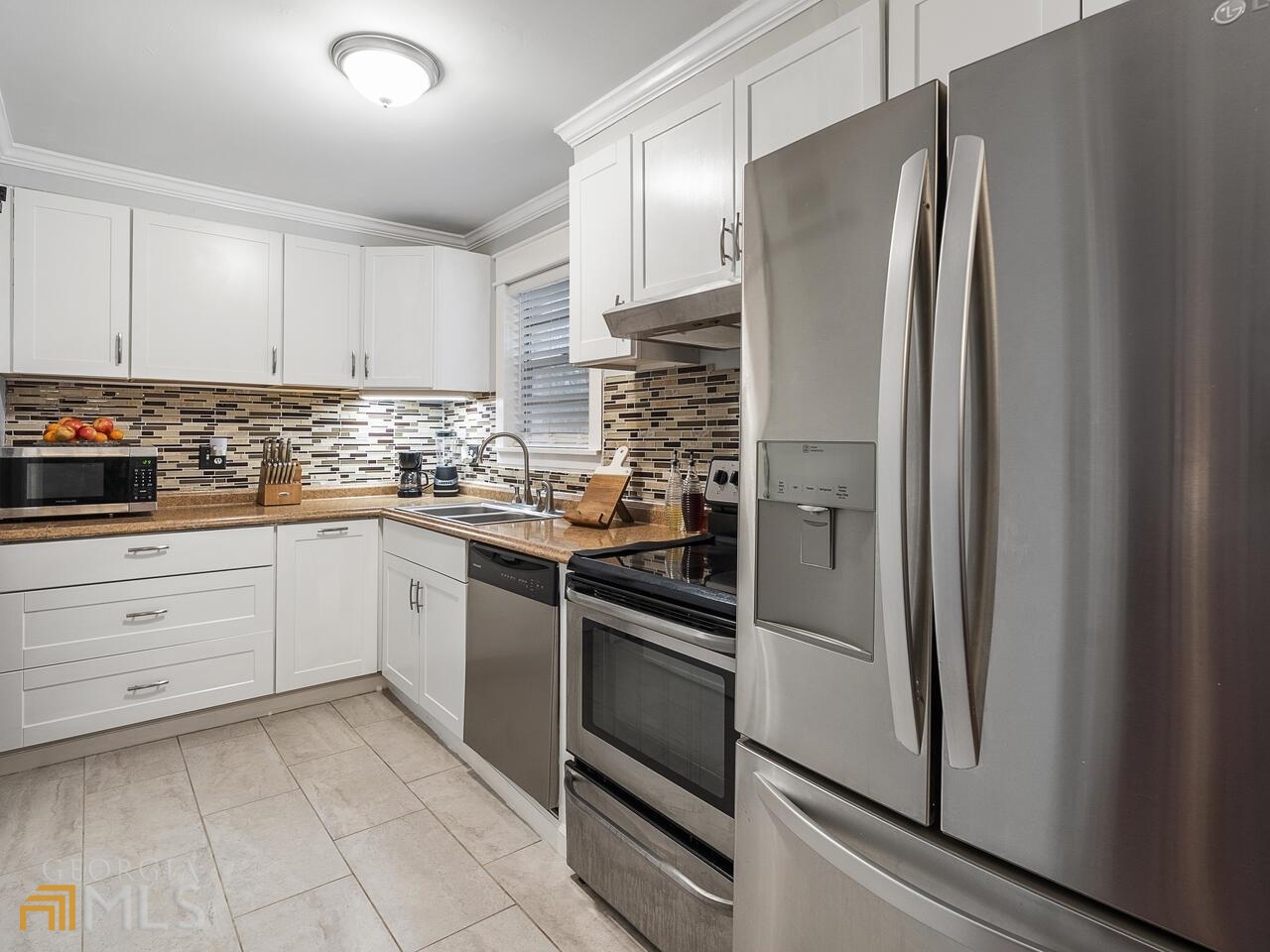 Beautiful Completely Renovated 3 bedroom, 2.5 bathroom Townhouse! The living areas have engineered hardwood flooring , kitchen is equipped with lovely white cabinetry, a glass tiled backsplash, and stainless steel appliances. Upstairs, the bedrooms have new carpet, and updated master and main bathrooms. The home features new light fixtures throughout, a tankless water heater. No FHA loans are allowed in this community. It is a Gated community, close to the interstate, shopping, restaurants and the Atlanta airport.