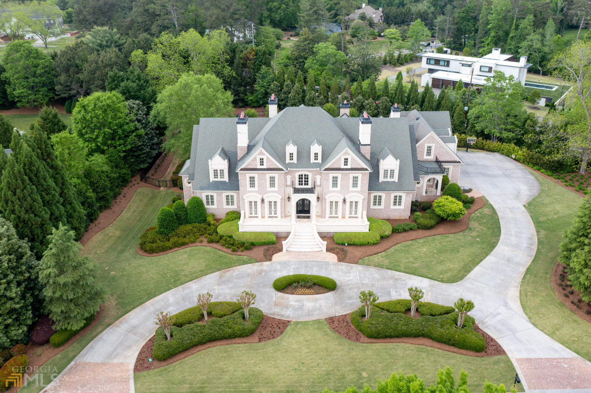 Gorgeous Custom built estate home on 2.3 acres in Glenayre, a gated guarded neighborhood in Roswell. This custom designed luxury estate will not disappoint with 4 sides brick, 7 HVAC, 8 Fireplaces, 3 theaters, 2 laundry rooms and in-law suite with kitchenette. The approach is stunning with 12C glass and wrought iron entry doors, and upon entry you will be greeted by stunning architectural details and a sweeping circular staircase, marble floors and an open floorplan that basks in natural light. Additional features include a gourmet kitchen with beautiful furniture grade cabinetry, glass door fronts and designer uplighting. Exotic granite countertops, commercial grade stainless appliances, large breakfast bar, and breakfast area and open to an elegant keeping room with cathedral ceiling, built in bookcases, fireplace and access to the patio. There is a catering/butler pantry hidden behind the main gourmet kitchen and offers built-in upper and lower cabinets, granite countertops, sink, perfect for the entertainer! There is a grand dining room to seat 16 comfortably and boast double French doors and heavy detailed trim. The mud room features building lockers, coat racks and cubbies and is convenient to the laundry room. The highly detailed study is a showstopper with hand milled stained wainscoting, coffered ceiling, accented by a limestone fireplace. Elegant owners' suite boast coffered ceiling, designer lighting, fireplace, a morning bar with refrigerator and granite countertops, spa-like bath includes a walk-in travertine shower, soaking tub, his and her vanities with dedicated make-up seating, and a grand dressing room with a center island. Upper level offers 4 bedrooms all with en-suite baths and large walk-in closets, 2nd laundry and theater room. Terrace level does not disappoint with a large bar with beautiful cabinetry and granite countertops overlooking the billiard room. A bedroom suite with full bath and kitchenette. Additionally there is the workout room, 2 full theater rooms, game room, learning/study room, and sports room and potential for a 5th car garage. The property is a private outdoor paradise and features a waterfall wall from the spa into the saltwater pool, and there are fountains in the tanning shelf and an expansive travertine pool deck. The screened lanai with fireplace and large seating area overlooks the manicured oasis. Minutes away from the best public and private schools, close to shopping and parks and easy access to downtown.