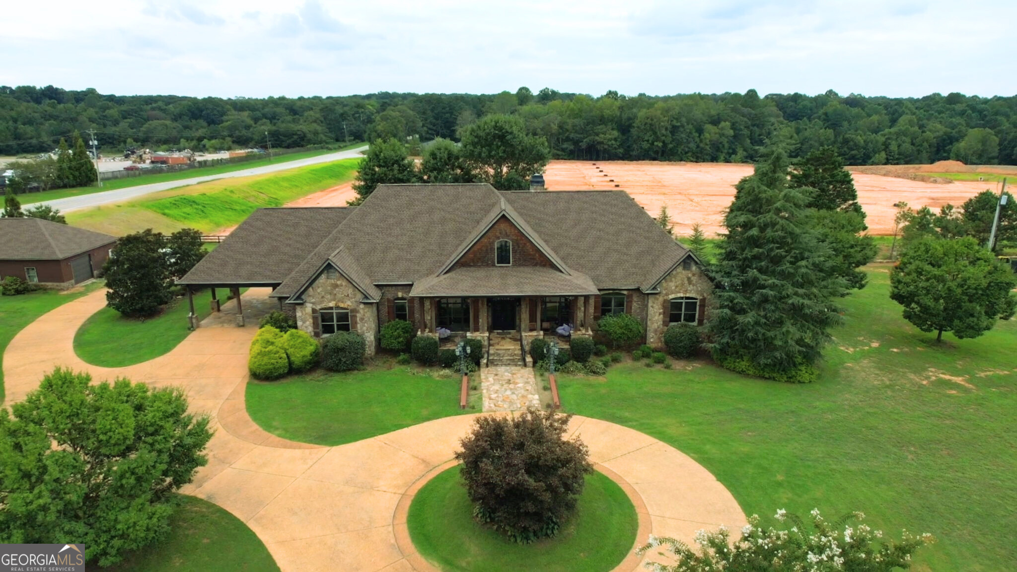 ENDLESS POSSIBILITIES! Amazing opportunity to own this multi-use property in the ever growing Jackson County. PREMIER LOCATION! Primary residence features a 4 SIDES BRICK home with circular driwaway, rocking chair front porch, porte-cochere for convenient covered entry, flagtone patio with outdoor fireplace and built-in grill. Inside find an expansive great room w/stone fireplace, chef's kitchen, 4 Bdrms/3.5 baths, sitting room and more! Additional buildings on the property include 1,500 sq ft workshop and 2,600 sq ft potential guest house or workspace. 6,400 sq ft concrete pad was poured to accomodate additional building with dock high door(s). ALL 3 STRUCTURES FEATURE NEW ROOFS. Situated on 4.66 open acres along Hwy 124 and Jones Road, this could be the perfect location for your next venture!