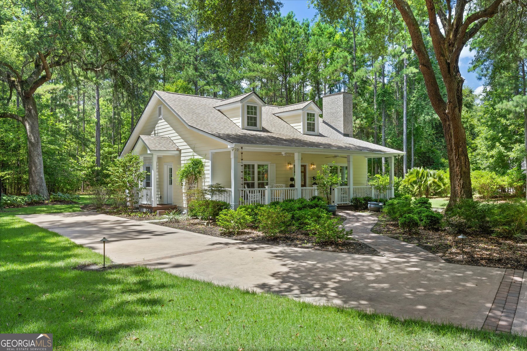 Charming cottage on nearly 2 acres of natural beauty! Tucked away in a serene setting, this elegantly designed home offers a rare blend of privacy, charm and modern comforts. A picturesque driveway winds through mature trees, welcoming you to a home that feels straight out of a fairy tale. The lush, manicured landscaping provides the perfect setting for a peaceful outdoor oasis. Inside, the gourmet kitchen is a standout, featuring a gas stove, custom cabinetry with wood-paneled appliances and glass door accents for a seamless built-in cohesive look. The cozy living room with fireplace invites you to unwind and relax while the cathedral ceilings add volume and light. The bathroom is thoughtfully designed with a sleek walk-in shower for a clean, contemporary feel. Situated in a desirable, up-and-coming Richmond Hill location free from HOA restrictions and flood insurance requirements. Whether you are seeking a tranquil primary residence, or the perfect weekend retreat, this unique gem delivers timeless charm on a truly special piece of land.