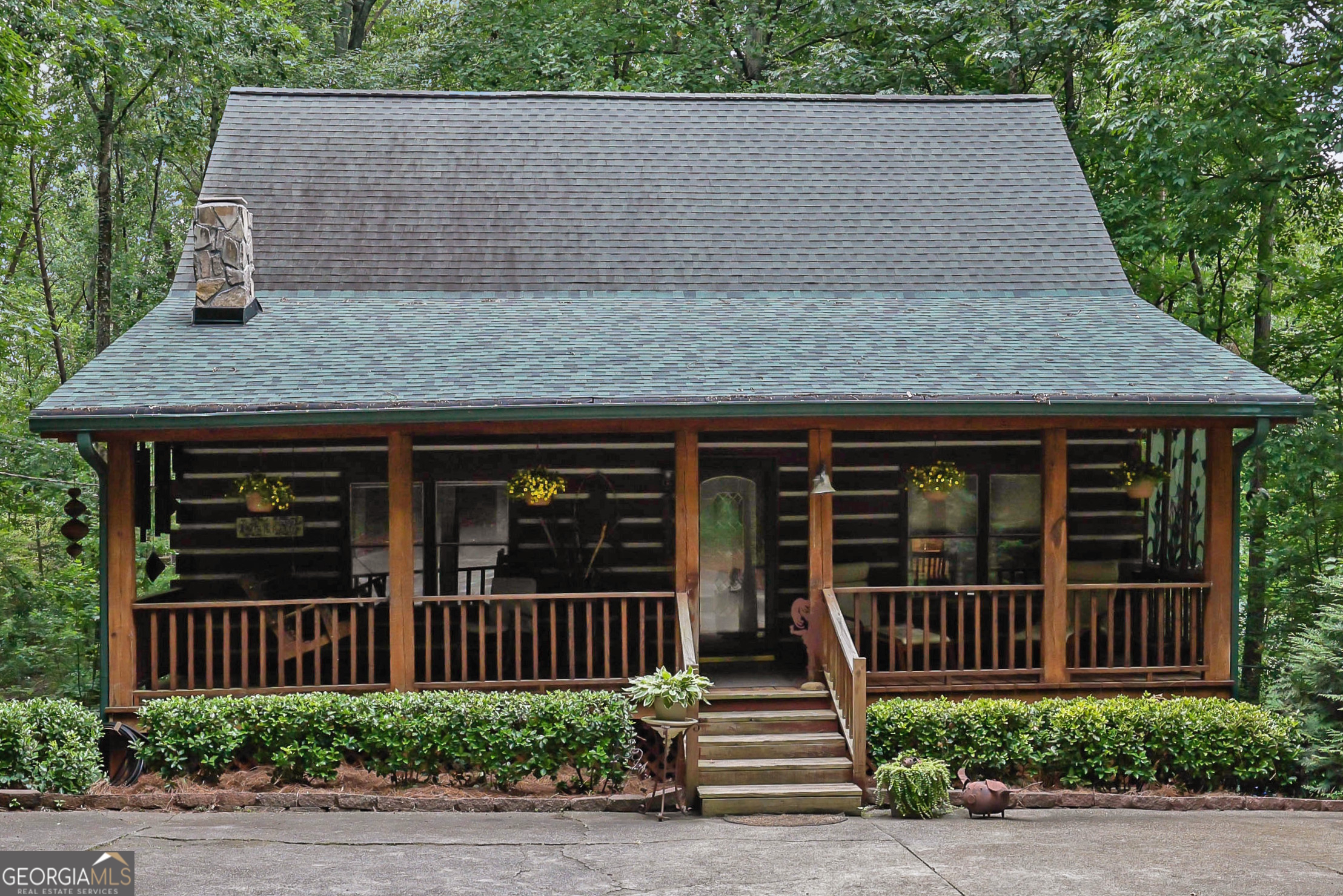 Escape to your own private retreat just minutes from Downtown Woodstock and Roswell! Set on two serene acres with beautiful oak hardwoods, this stunning hewn log cabin home offers the perfect blend of rustic charm and modern comfort. Tucked away from the road for ultimate privacy, you'll feel like you're in the mountains while still being close to shopping, dining, and all that Woodstock and Roswell have to offer. The welcoming front porch is ideal for morning coffee, while the enclosed screened/glass back porch provides year-round enjoyment with peaceful backyard views. The fenced front yard is perfect for pets, and the soothing sound of birdsong completes the tranquil setting. Inside, the main level features hardwood floors under the carpet and a charming wood-burning fireplace that can heat the entire home in the winter, plus a propane gas backup heat system for peace of mind. The unfinished basement spans the full length and width of the home, is stubbed for a bathroom, and is ready to be transformed into anything your lifestyle requires. Enjoy energy efficiency year-round thanks to the natural insulation of log construction. This solidly built home is designed to stand strong against whatever Mother Nature brings. If you've been dreaming of a private log cabin lifestyle with modern convenience close by, this is your chance. Schedule your visit today-this one is full of charm and won't last long!