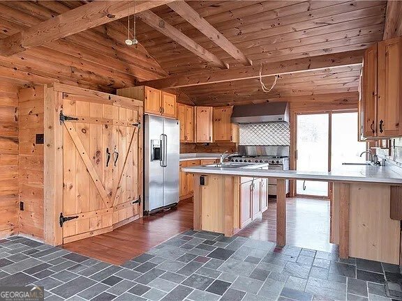 For Rent - 2405 Mountain Road, Milton, GA 30004 Tucked away on 15.46 acres in the heart of North Fulton's horse country, this 2 bed / 2 bath log cabin duplex that offers privacy, charm, and versatility. The home features slate floors, a chef's kitchen with professional-grade appliances, and wrap-around decks with views in every direction.