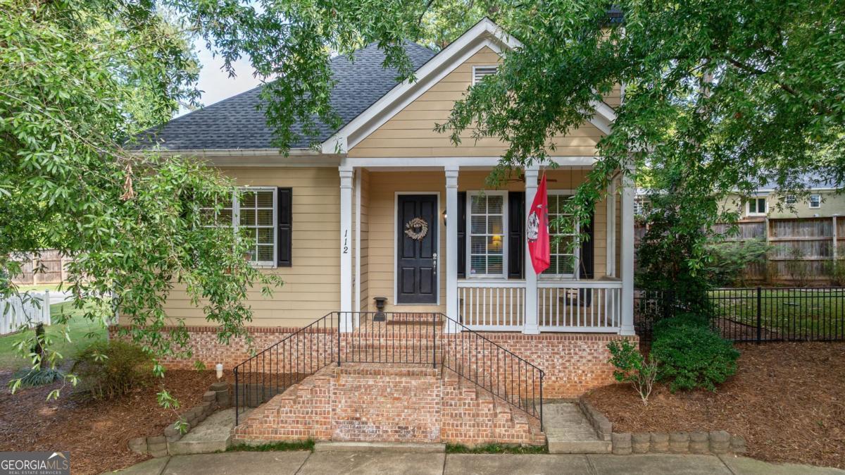 Welcome to this charming single-story cottage offering easy level living in one of Athens' most convenient locations. A classic rocking-chair front porch leads into beautiful hardwood floors, tall ceilings, and an open layout with crown molding, updated baseboards, and a cozy wood-burning fireplace. The kitchen features granite countertops, wood cabinetry, breakfast bar, and stainless appliances, including a French door refrigerator. Two spacious bedrooms each offer en suite baths, ceiling fans, and generous closets. The primary suite includes dual closets and a garden tub/shower, while the guest bath has a tiled tub/shower. A powder room and laundry room add convenience. Outdoor living shines with a grilling deck, paver patio, and fenced backyard. With a newer roof and HVAC, plus HOA-covered landscaping for simple living, this home sits on a quiet street across from Athens Country Club, near Publix, Piedmont Hospital, UGA Medical College, Normaltown, and downtown.