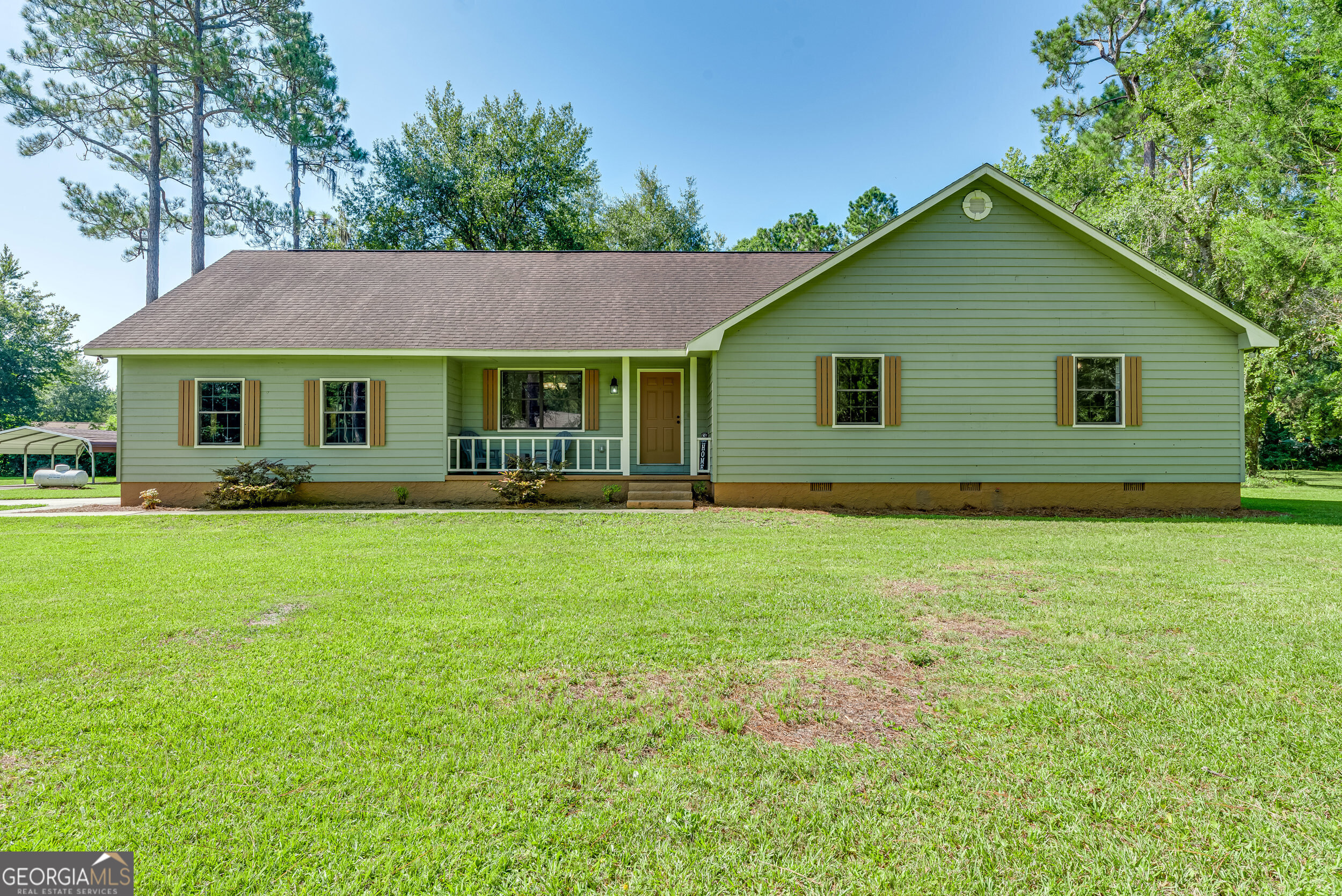 Over 2.6 acres and a home in the heart of Woodbine! This well-maintained 3 bedroom, 3 bath home offers room to roam-inside and out-and is located just about 20 minutes from NSB Kings Bay. Inside, you'll find a welcoming foyer entry, a large living room with a cozy stone fireplace, and a country-style kitchen complete with a pantry. The generous utility room includes a sink, and the 3rd full bathroom is conveniently located nearby with access to the backyard-perfect for easy clean-up after outdoor activities. The primary bedroom features a barn door leading to the ensuite bath with a walk-in closet and double vanity with granite counters. Two additional bedrooms are spacious and share access to a full bath. Enjoy year-round relaxation on the screened porch overlooking the expansive yard, garden plots, and a producing pear tree with the sweetest little pears. The property also includes an oversized 2-car garage and a detached carport, with plenty of space for parking and storage.On well and septic, so there are no city water or sewer bills. Located in Flood Zone X, so no flood insurance is required. This listing consists of two parcels being sold together-ideal for a future second home, guest cottage, or simply enjoying the space and privacy of a large country lot. Enjoy the charm of country living with the convenience of town access! Situated near the Satilla River and Woodbine Riverwalk, this home offers access to kayaking, fishing, hiking, and wildlife observation. Enjoy weekend jam sessions at the Woodbine Opry, stroll through historic downtown streets, pick blueberries in season at Morning Belle Farms, or join the local Crawfish Festival and summer concerts.