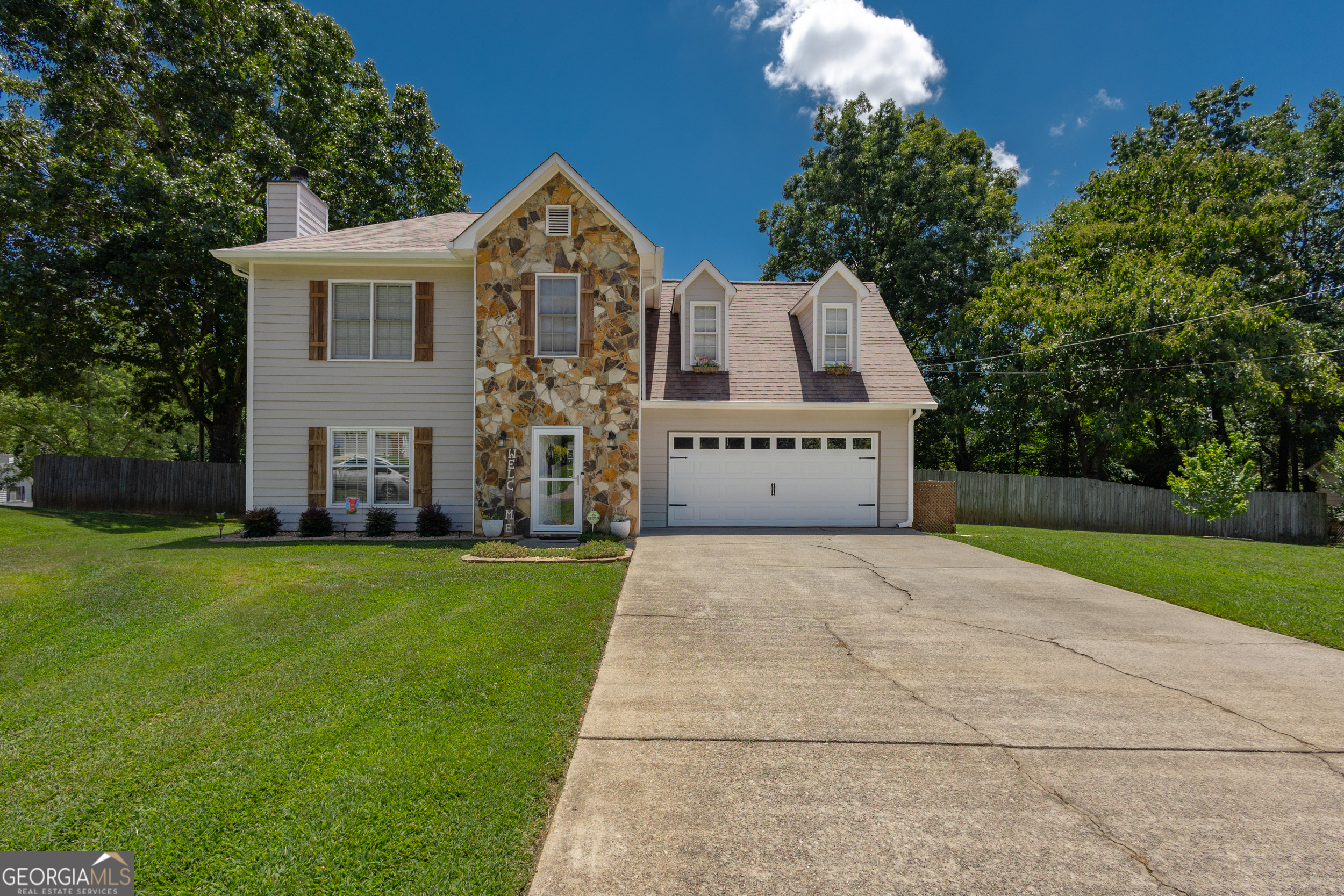 Well-maintained beautiful 4 bedroom, 2.5 bathroom home is minutes to downtown Sugar Hill! The lovely kitchen features white cabinetry, granite countertops, tile backsplash, separate island, stainless appliance package, and eat-in breakfast area with bay window and amazing view of the backyard. Separate formal dining room. Spacious family room presents a stone surround fireplace with raised hearth, white mantle, and ceiling fan. Updated half bath on main level. Upstairs you will find the oversized owner's suite with complete remodeled bathroom - huge tile shower with bench, 2 inserts, sliding glass doors, and double vanity. Oversized secondary bedrooms all with ceiling fans. Enormous backyard with privacy fence, large patio area, swing that is perfect for enjoying your morning coffee of evening glass of wine, playground area, planter space, and separate storage building. Additional features: high end laminate flooring, water heater, garage door - all just 2 years young, all toilets replaced to low flow, and plumbing on main level to PVC. This is your new place to call home!