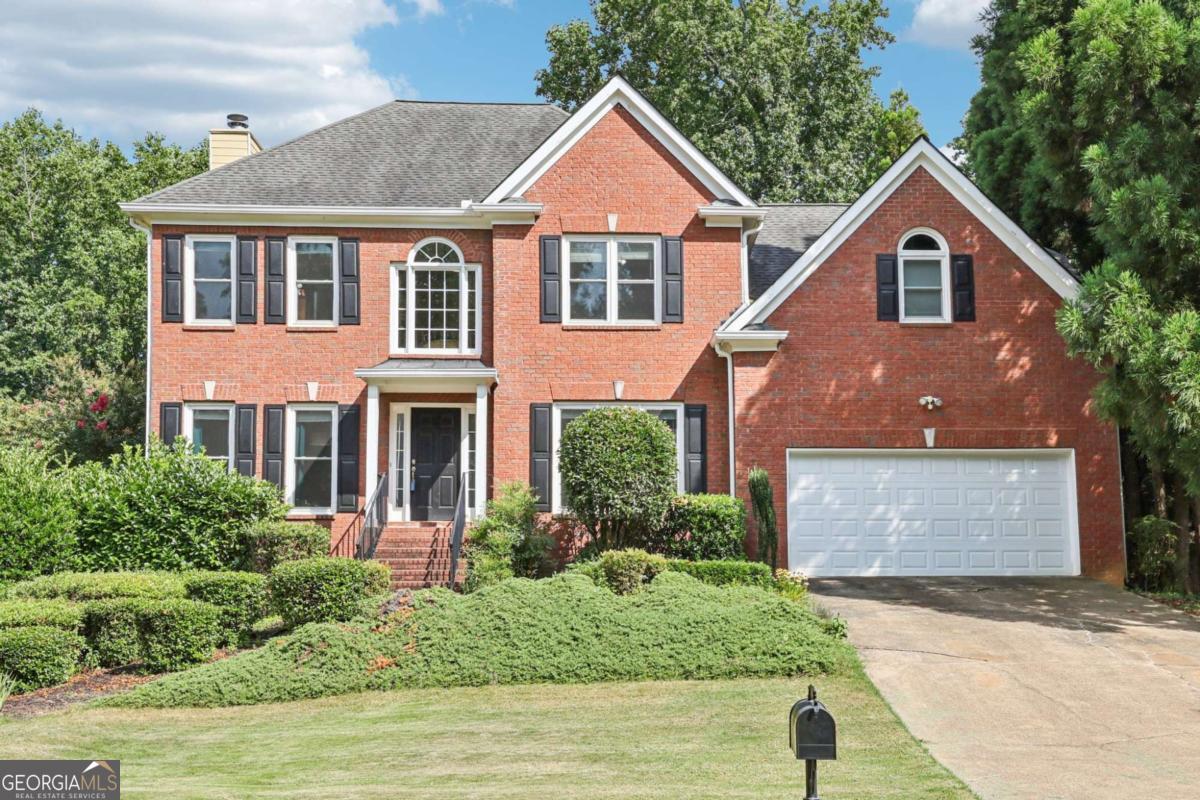 Located in the highly sought-after NORTH GWINNETT HIGH SCHOOL district! This spacious, light-filled home in the coveted Lansfaire community is designed for comfort, style, and effortless living. Set on a beautifully manicured front lawn, you're welcomed by a grand two-story foyer and hardwood floors. Elegant segmental arched openings lead to a formal living room on one side and a formal dining room on the other, featuring a tray ceiling and classic chair rail accents. The open-concept family room is bathed in natural light from a wall of windows that frame peaceful views of the private, wooded backyard. A cozy fireplace anchors the space, perfect for relaxing or entertaining. The adjacent kitchen is perfect everyday living and entertaining, offering granite countertops, stainless steel appliances-including double ovens-a breakfast bar, and a sunny breakfast nook with direct access to the oversized deck for seamless indoor-outdoor dining. A guest bedroom and full bath on the main level offer convenience and flexibility. Upstairs, retreat to the expansive primary suite featuring a tray ceiling and a spa-like en-suite with a large walk-in closet, dual vanities with room for vanity seating, soaking tub, and a glass-enclosed shower. Two spacious secondary bedrooms share a dual-sink hall bath, while a fourth bedroom includes a bonus area perfect for a playroom, office, craft space, or reading nook. Need more room to spread out? The finished basement provides incredible versatility, featuring a living area with custom built-ins and coffered ceiling, a full wet bar with sink and microwave, a bedroom, full bath, dedicated media room, and extra unfinished storage space. Enjoy the fully fenced backyard, complete with a covered lower patio and expansive upper deck, both overlooking lush green space-ideal for entertaining or peaceful retreats. Lansfaire offers a fantastic array of amenities, including a pool, tennis courts, playground, and open green spaces. All just minutes from everyday conveniences like Publix, Starbucks, and Chick-fil-A. Don't miss your chance to call this exceptional home yours-schedule your private showing today!
