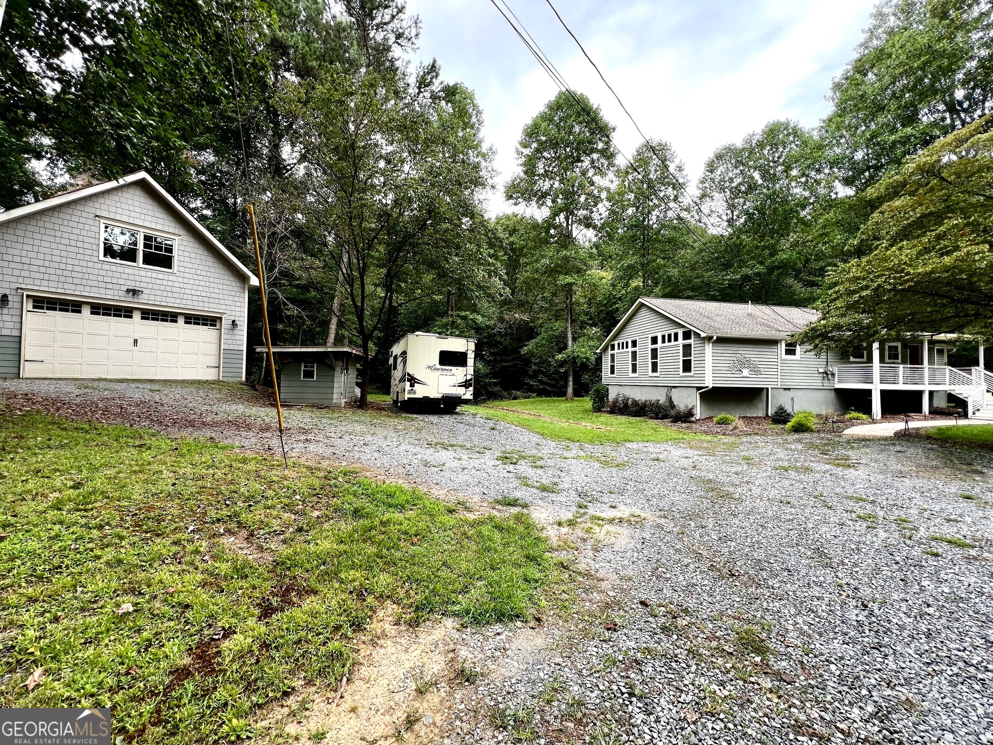 Charming Renovated Ranch Home in Peaceful Ellijay Nestled on a serene peninsula on 2.66 acres surrounded by a peaceful creek, this beautifully renovated 3-bedroom, 3-bath home offers privacy and soothing water views. Enjoy the water views from both the rocking chair front porch and back porch-perfect for unwinding while listening to the soothing sounds of flowing water with a cup of your favorite morning coffee or nightcap. Turkey Creek does have stocked trout, typically twice a year (March and May) Inside, the spacious living room features high ceilings, gleaming hardwood floors, and a wood-burning buck stove with custom stonework extending up to the ceiling. The modern kitchen boasts custom-made cabinetry, granite countertops, and stainless steel Frigidaire appliances, blending style and functionality. The bathrooms also showcase custom cabinetry for a cohesive design. Two master suites each include a full private bathroom, providing comfort and convenience. A detached two-car garage/workshop with a loft offers ample storage or the potential for a cozy office or apartment space. This home is ideal for a family retreat or a short-term rental opportunity, combining tranquility with easy access to local amenities.