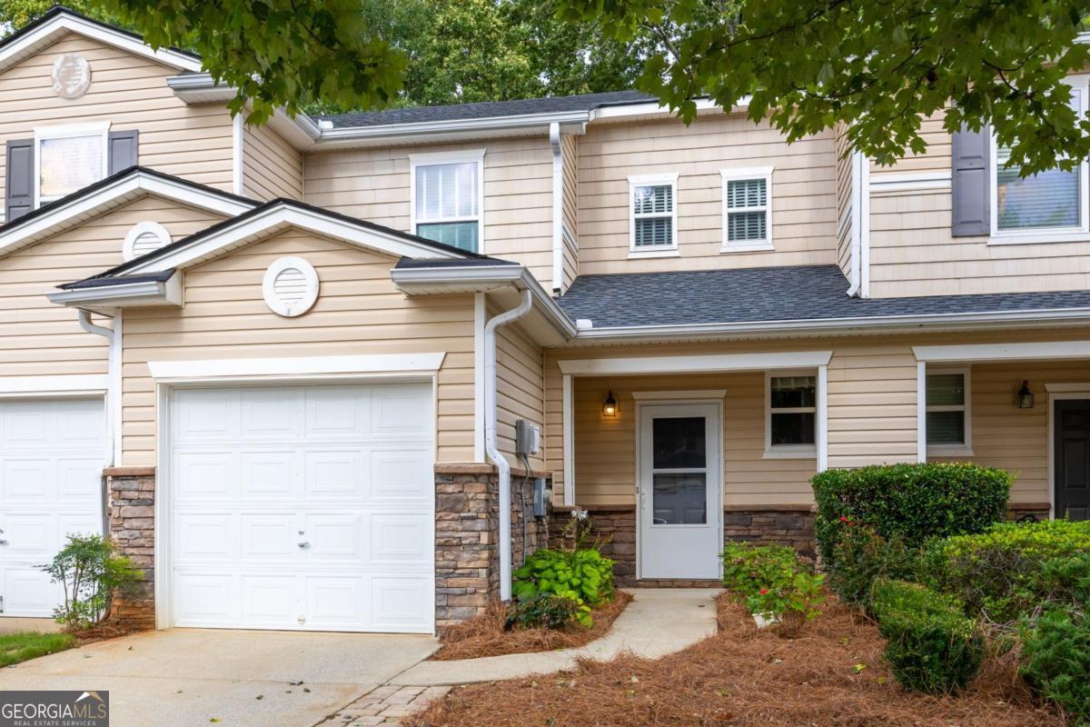 Discover this stylishly updated 2-bedroom, 2-bathroom townhome ideally situated in the sought-after Ridge Mill community - just minutes from I-75, Kennesaw State University, and the vibrant downtowns of Woodstock, Kennesaw, and Acworth. The open-concept main level showcases a modern kitchen with new custom cabinetry, quartz countertops, under-cabinet lighting, an oversized farmhouse sink, a stainless-steel vent hood, 9 foot ceilings and counter-height bar seating for four - perfectly connected to the spacious family room and dedicated dining area for effortless entertaining or quiet evenings at home. Upstairs, the generous primary suite features a walk-in closet and a beautifully renovated en suite bathroom with a double vanity. A secondary bedroom, second full bathroom, and convenient laundry room with full-sized top-load washer and dryer complete the upper level. Both bathrooms are upgraded with new vanities, LifeProof LVP flooring, custom mirrors, and shiplap or judges panel accent walls. Stay comfortable year-round with a state-of-the-art two-zone Trane HVAC system installed June 2023, a brand-new roof installed July 2025, and energy-efficient double-pane windows complete with upgraded blinds. Keep your car out of the weather in the full-size garage, with parking for at least two more vehicles in the extended driveway. Step outside the back of the home to a charming paver patio overlooking serene woods, or enjoy Ridge Mill's community park and gazebo, sparkling pool, and playground, with exterior and grounds maintenance covered by the monthly HOA fee. Don't miss your chance to own this move-in ready gem - schedule your showing today!