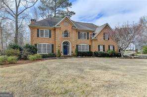 Welcome to this elegant brick traditional home in sought-after Sentinel Lake! This beautiful residence offers timeless charm with an impressive two story entry as you walk through the front door and a view of the fireside living room with floor to ceiling windows and built-in bookshelves. Guest bedroom on the main level is perfect for visitors, an office or a playroom. Kitchen features updated bronze hardware, stainless appliances and a walk-in pantry. Dining Room can accommodate 12 guest comfortably. Living Room could be an additional sitting space or office. Main level laundry room is huge with a mud sink and plenty of storage for those Costco runs! Upstairs features three large secondary bedrooms all with their own private en-suite. Oversized primary suite includes a fireside sitting room, his and her custom closets and private en-suite bath. The unfinished basement provides endless possibilities for customization. Natural sunlight throughout this home. You can't beat this location-close proximity to I-75, Sope Creek Park and Trails, and The Battery/Truist Park. Eastvalley elementary is a brand new school.