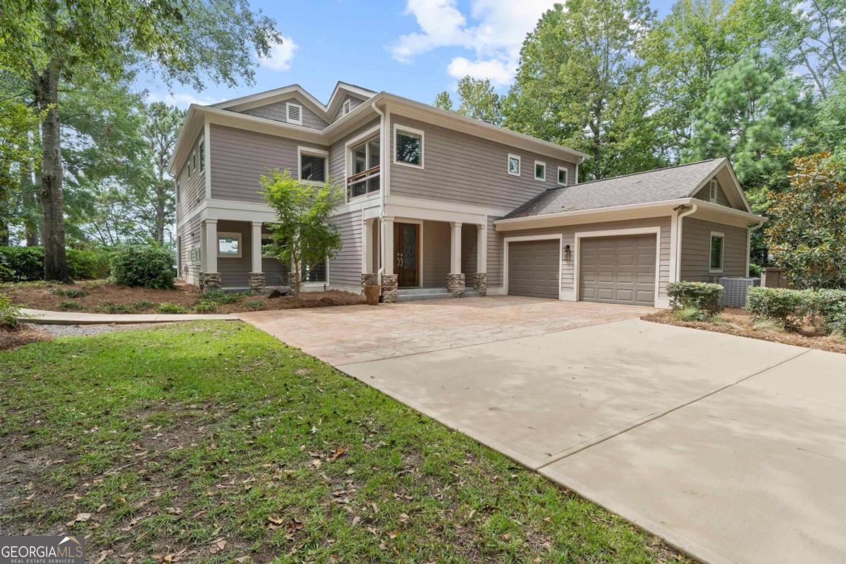 Enjoy the Big Lake Views as you enter this beautiful home in Reynolds Landing. Nicely updated and contemporary design with the large walls of glass capturing the beauty of Lake Oconee. This home was completely updated when purchased in 2010 and has been hardly lived in since that time. Wood ceiling accents the beautiful great room which is lowered 4 feet from the main floor. A 10-12 ft marble patio surrounds half the house to offer great outdoor space with room for expansion or a lakeside pool. Three large bedroom suites are on the second floor with distant views from the entire house. Main floor has a bedroom/office with full bath nearby. Large 2 car garage for storage. You must see this home to appreciate the quality and workmanship on the inside and to experience the unbelievable views and privacy from this level point property.