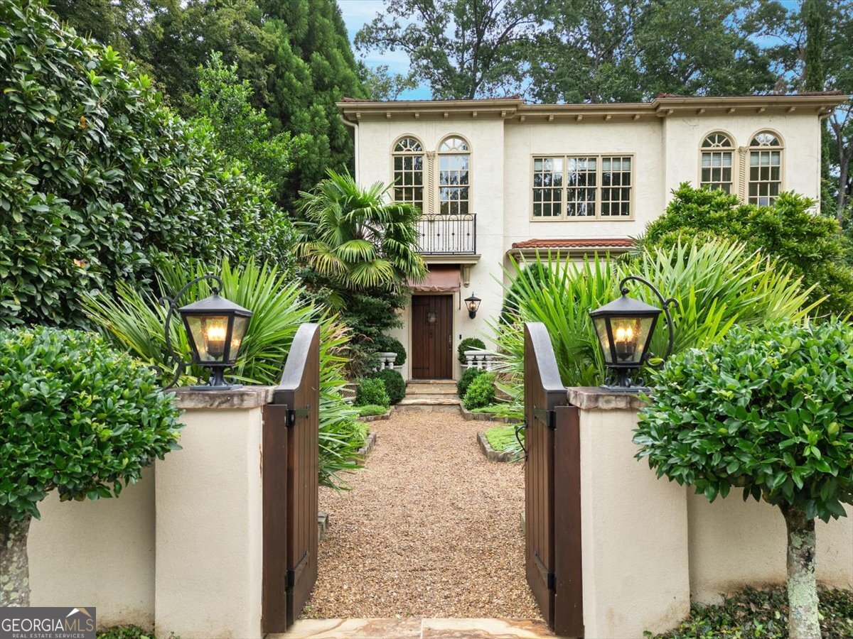A very special home in the sought-after Peachtree Heights East Neighborhood. This Spanish style home with tile roof welcomes you through a master gardener's courtyard. The two-story entryway captures your attention with a dramatic coffered ceiling and warm and inviting light. The main hallway calls you to the primary living space with 10 1/2 ft ceilings. It has a natural wood burning fireplace and open kitchen, with three sets of French doors revealing the private garden oasis. The doors, each with half round transoms, face the morning sun and bath the entire space with natural light. The kitchen, recently updated, features a granite island, marble countertops surrounding the Wolf cooktop, Wolf convection oven and separate Wolf microwave and Sub-Zero refrigerator. The space connects through a butler's pantry to the formal dining room, which enjoys three large windows with half round transoms. A quiet sitting area with Southern exposure is located off the main living space. Upstairs are four bedrooms, with the Primary suite at the end of the hall, facing East. A set of French doors opens to a Juliette balcony overlooking the back garden and pool and the Ipe deck below on the main floor. The Primary enjoys a fireplace with gas insert and the in-suite bathroom has his and hers walk-in closets, separate vanities, soaking tub, shower and private water closet. There is even space for a coffee and wine bar. Two of the bedrooms have in-suite baths and walk-in closets, while the third bedroom, which can also function as an office, has access to the full hall bath. There is also a newly remodeled laundry, with quartz counters and separate scrub sink. The daylight basement boasts an additional bedroom and full bath, a separate workout room, finished under stair space and a spacious great room with in-ceiling speakers for family movie nights or football Saturdays. The space opens through two more sets of double French doors to the covered and elevated patio, which provides access to the back courtyard and saltwater pool. Masterfully land and hardscaped, with an outdoor structure for storage and a teak swing. The meticulous side path, along the southern exposure of the house, connects the back to the front through a magical garden. The house boasts a two-car tandem garage, separate landscape irrigation meter, Bluetooth controlled interior and exterior lighting, three heating and cooling zones and a fully foam insulated attic. Hardwood floors on the main with custom sisal floor coverings, with Spanish tile in the daylight basement. The Duck Pond, Buckhead dining, Garden Hills Pool and award-winning public and private schools are all easy walks from this central location. This is truly a unique and extraordinary retreat in the middle of Atlanta!