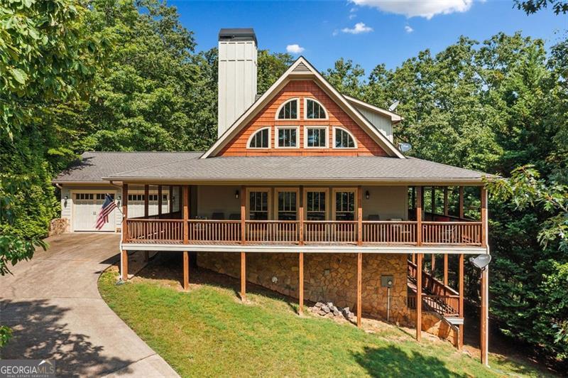 Come home to this mountain retreat located in the sought-after, gated Lake Arrowhead community. This custom home has an extensive wrap-around double-deck porch, perfect for outdoor entertaining or enjoying peaceful wooded views year-round. Step inside to soaring vaulted beam ceilings, a dramatic 2-story stone fireplace, and an open-concept living area filled with natural light. The spacious main-level master suite features its own cozy fireplace, a spa-like bath with double vanities, jetted soaking tub, and a separate walk-in shower. Additional highlights include an unfinished terrace level, lofted flex space, and timeless mountain architecture throughout. Enjoy resort-style amenities including a private lake, golf, pools, trails, and more - all just an hour north of Atlanta