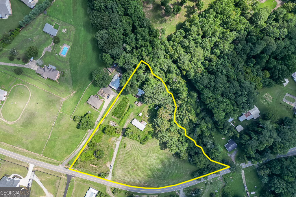 Gorgeous 3.714 +/- Acre property located in the heart of West Forsyth County! Prime location near Greens Corner and the new Publix at Tribble Crossing make shopping and dining convenient. This beautiful property showcases gently rolling pasture with a pole barn that can be used to house animals and equipment. Fruit lovers will appreciate the presence of mature Muscadine Vines, Scuppernong Vines, fig and pear trees, which add variety to the property's bounty and provide seasonal harvests. The creek at the rear of the property enhances its appeal, serving as a natural boundary and habitat for local flora and fauna. Deer, birds, and other wildlife are frequent visitors, making this acreage ideal for nature lovers and outdoor enthusiasts. The double wide mobile home is situated on the property offers immediate shelter and flexibility for future owners. While the mobile home will require some renovation and repairs to restore it to livable condition, its presence adds value and utility; it can be updated for comfortable living, used as a guest house, or serve as a temporary residence while building a new home.