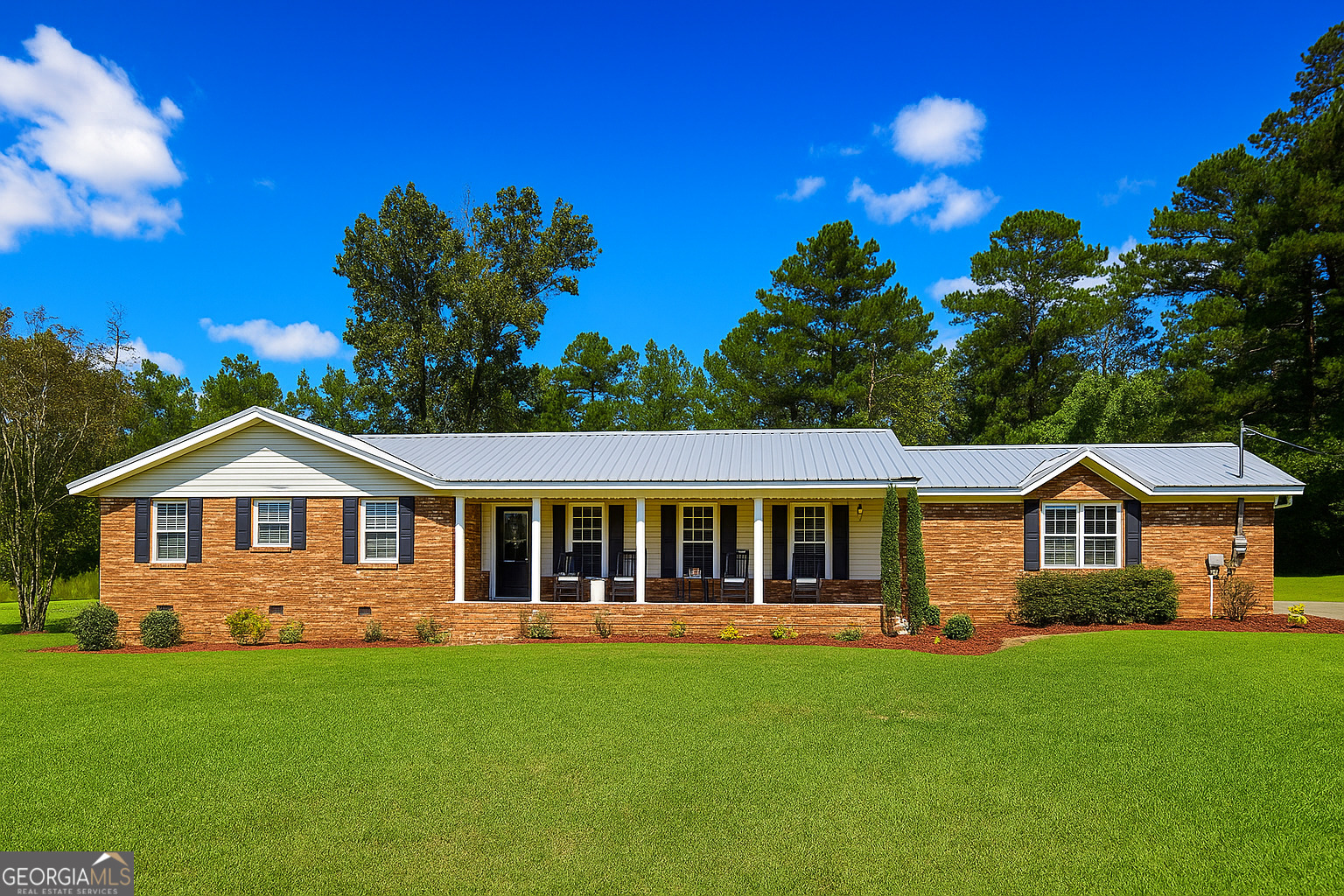 The Ultimate Country Escape - Just Outside Milledgeville! Peaceful living awaits in this beautifully updated ranch style home on 11.15 acres, located in a USDA-eligible area. Designed for comfort & entertaining, the home features an open layout with 2 spacious living areas, fireplace, built-ins, and bamboo flooring. The renovated kitchen shines with granite counters, stainless appliances, modern cabinetry & island seating, flowing into a formal dining room and sun-filled den with brick accent wall-perfect for an office or studio. The primary suite offers dual closets, double vanity & walk-in shower, while 2 guest bedrooms share a Jack & Jill bath. Step outside to your private oasis with a saltwater pool, outdoor bar & grilling area, fire pit, fenced garden/chicken area, detached outbuilding & large storage shed. Recent upgrades: metal roof (2022), AC & ductwork (2024/25), and tankless water heater (2022). Enjoy the privacy, space & convenience of country living-all move-in ready! Seller is a licensed real estate agent in GA & FL.