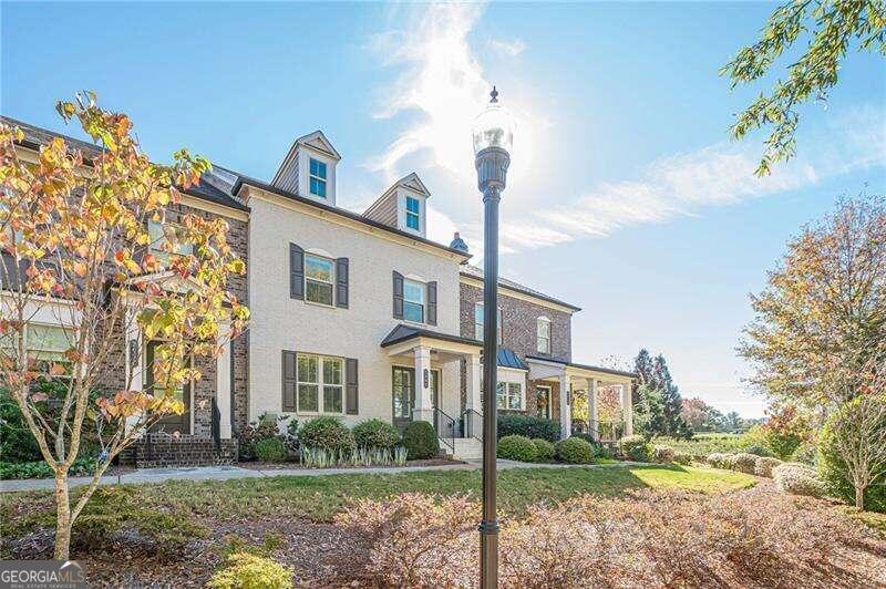 Make this YOUR HOME FOR HOLIDAYS ! Make this season beautiful and unforgettable in this MOVE_IN_READY home and own a piece of Alpharetta . Discover Your Dream Home in Encore Walk. Welcome to your new maintenance free lifestyle in an exceptional townhome in Alpharetta. Offering a blend of high quality and luxury . 10 foot high ceilings on the main floor and high ceilings upstairs with hardwood floors throughout! This stunning 3-bedroom, 2.5-bathroom townhome spans three stories and showcases $30,000+ in builder upgrades! The open concept kitchen overlooks the spacious dining area and large great room with an electric fireplace. The kitchen is a chef's delight with white cabinets featuring soft-close technology and under-cabinet lighting, has stainless steel appliances including a vented range hood, gas cooktop, dishwasher and built-in microwave. A stylish white tile backsplash completes the modern look. Quartz countertops on the oversized island and extensive kitchen counters along with a walk in pantry complete this stunning kitchen. . Step outside the kitchen to the covered porch with electronic sun screen which encloses the space, perfect for relaxation. Ascend the second level and retreat to the tranquility of three bedrooms and two full bathrooms. The primary suite boasts a glamorous bathroom with customized closet. The laundry room completes this floor. The lower level with rear entry garage, opens to a flex space perfect for an office, playroom or gym with a 1/2 bath. Each floor has it's individual thermostat. Parking is effortless with a 2-car garage and 2 additional driveway spaces. This home is walking distance to Fulton Science Academy. Being so close to downtown Alpharetta, Avalon and North Point and Interstate 400 make this location ideal!
