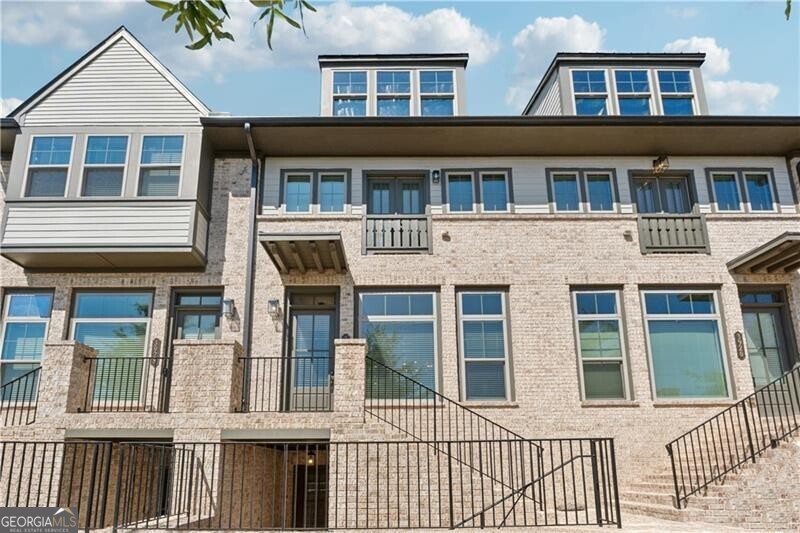 A beautifully appointed townhome in sought-after Reverie on Cumberland!  This elegant, like-new residence offers open-concept living with abundant natural light and designer details throughout.  The chef's kitchen boasts quartz countertops, large island, and premium stainless-steel appliances - seamlessly connecting to a spacious living area and private balcony.  The primary suite features a spa-inspired bath with double vanities and a generous walk-in closet.  Secondary bedroom with en-suite bath is perfect for guests or a home office.  Lower-level flex space with full bath offers the option for a private guest floor.  Enjoy resort-style amenities including a sparkling pool, clubhouse, fitness center, and gated entry.  Ideally located just minutes from The Battery, Truist Park, Vinings restaurants, and major highways - offering effortless, low-maintenance luxury living in the heart of it all!