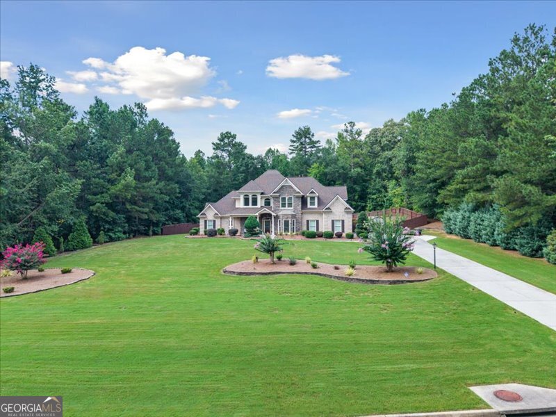 Located in Oxford's upscale community Longview Creekside. This home features over 4400 HEATED square feet on a 1.76 ACRE estate-size lot on a quiet cul-de-sac street with 4 bedrooms, 4.5 baths, office/5th bedroom, 4-sides BRICK exterior, 3-CAR garage with car charging station, 2-story family room with coffered ceiling/ FLOOR-to-CEILING stone fireplace with blower/ entertainment center & bookshelves, open kitchen to family room with breakfast area/ tile floor/ tile backsplash/ quartz surface countertops, new refrigerator, dishwasher, cooktop & microwave (all 2025), Gas range with electric dual ovens, upstairs media room with skylight & electric shade with remote, 2 owner's suites (one downstairs & one upstairs), all-season sunroom with floor-to-ceiling screened windows, separate dining room, large laundry room with wall cabinets/ wash sink & separate exterior entrance, Saltwater Pool (2022) with beach entry & stone border with new pool cleaner controller, Roof (2022), Carpet (2022) & Water Heater replaced in (2019), 4 new water efficient toilets . Additional highlights include guest bedroom downstairs with separate entrance to sunroom, California closets & PRIVATE BATH, 1/2 bath on main for guests, Anderson storm doors with sliding glass/hidden screen, crown molding throughout, flagstone front porch, CUSTOM built gazebo with light/fan/electric & TREX flooring, STAINED GLASS windows over both owner suite jetted tubs, alarm system/ring doorbell & ring flood lights with cameras, privacy fenced back yard, storage building, garden house walls with raised beds (no roof), outdoor fire pit, river rock backyard drainage, covered wood storage for firewood, 6-person HOT TUB with Bluetooth speakers, cabinets & tool storage in garage, blueberry & fig bushes, 2-story windows in family room and windows above the stairs feature custom electric shades with remotes, 3 separate thermostats plus Lennox mini-split in sunroom, professional landscaping and lawn sprinkler system front and back with smart phone controller, extended driveway & landscape lighting front & back. Conveniently located to Covington, Conyers Loganville & Monroe. Also nestled between Cherokee Run Golf Course & Honey Creek Golf & Country Club, Conyers. Ashton Hills Golf Club, Covington. Bear Creek and Providence Golf Clubs, Monroe. Cedar Lake Golf Club, Loganville & The Creek at Hard Labor, Rutledge. Schedule your private showing through Showing Time. Thanks and all the best! NO SIGN IN YARD. See "Other" in documents for preferred lender and incentives, floor plans, etc.