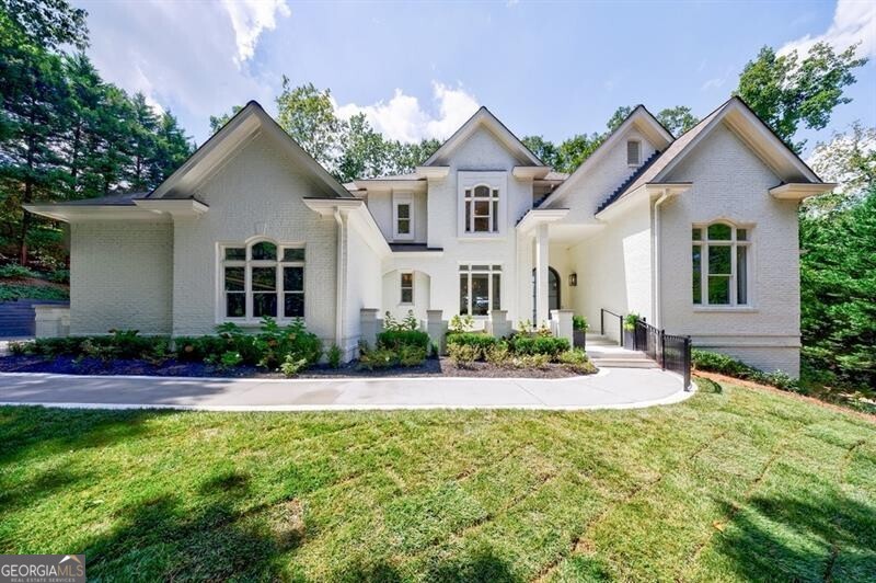 Thoughtfully renovated North Buckhead home has left no detail untouched, upgrades include: new exterior and interior paint, completely renovated kitchen, newly renovated bathrooms, new light fixtures, new fireplace surrounds, new grass etc. The light filled entry foyer welcomes you to a grand staircase and dramatic two story foyer. Large formal dining room sits in the front of the house and large living room with wet bar and fireplace sits in the back of the house and overlooks the backyard. Kitchen is light and airy with marble counters and matching island, Viking appliances and opens to the breakfast room and keeping room with fireplace. Laundry room is conveniently located off of the 3 car garage. Admired oversized primary suite on main has sitting room with fireplace. Completely renovated primary bathroom has dual vanities, separate soaking tub and shower. Large walk-in closet sits in the back of suite. Handsome office sits in the front of the house but could also be used as a library or playroom. Upper level staircase leads to 3 bedrooms all with en-suits baths. Terrace level truly has it all and could be used as a in-law suite or au-pair suite with separate driveway and one car garage as well as 2 bedrooms and 2 full baths, kitchenette and living space. Basement level also includes wine cellar and additional storage room with access to the level backyard. This property has a separate street off of Peachtree Dunwoody allowing for additional parking and easy access in and out of the driveway.