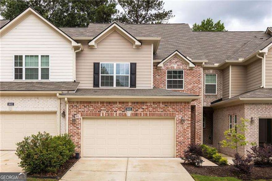 Tucked inside a quiet, gated community in Marietta, this newer construction home delivers the perfect mix of comfort, convenience, and calm. Just minutes from the charm of Marietta Square, the location makes everyday life easy without sacrificing peace and privacy. Step inside to warm hardwood floors and an open main level that feels spacious and welcoming. The living room centers around a cozy fireplace and flows effortlessly into the kitchen and dining area, creating a space that's just as great for relaxing as it is for hosting. The kitchen is the heart of the home, featuring a large central island, stainless steel appliances, granite countertops, gas range, and abundant cabinetry to keep everything within reach yet out of sight. French doors off the dining area lead to a private patio surrounded by lush greenery, giving you that tucked-away, treehouse feel. Whether it's coffee in the morning or wine in the evening, this space is made for slowing down. Upstairs, you'll find two generously sized guest bedrooms, a full bathroom, and a laundry room that keeps chores contained. The oversized primary suite is a true retreat with space to unwind, a large walk-in closet, and a spa-inspired bathroom with double vanity, walk-in shower, and separate water closet. There's more to love; the huge unfinished basement is already stubbed for a bathroom and ready for whatever you need next, think home gym, guest suite, office, or media room. Enjoy socializing with neighbors at the community pool and let the pups run free at the dog park. Conveniently located near I-75, this one checks all of the boxes and then some!
