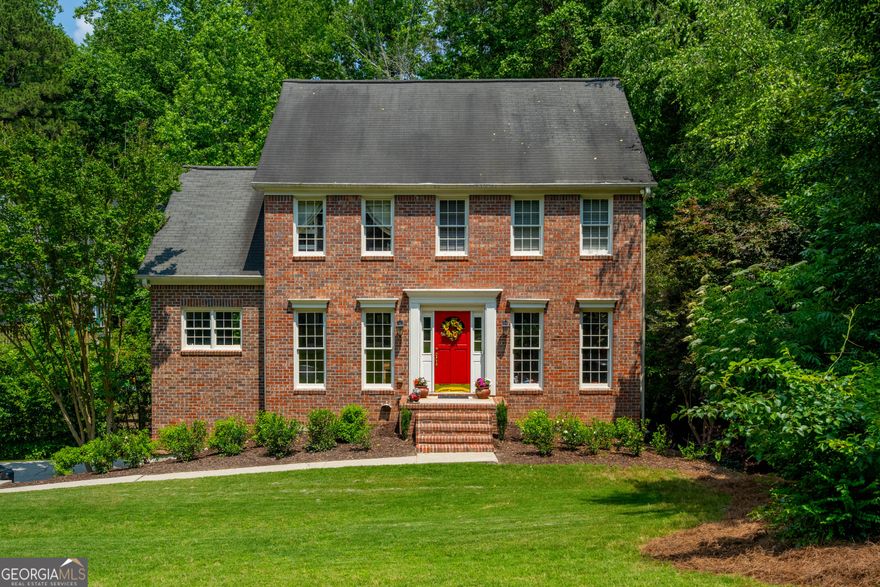 Sought after a brick Colonial home with the CUTEST backyard! Set back on a large lush lot with flowering shrubs and plants, the home exudes curb appeal. Inside the traditional floor plan provides privacy when needed but it offers an easy flow.  With the den/office/formal living area at the front as well as the family room and kitchen.  Offering granite counters, stainless appliances and plenty of cabinets this kitchen has everything one would need.  The adjacent dining room and cozy, fireside family room face the backyard which allows for a lot of natural light to flow through.  From here you have access to the large back deck which overlooks the adorable backyard featuring a creek and separate fenced areas to enjoy.  Upstairs the spacious Primary bedroom boasts a private en suite bathroom with separate tub and shower along with a double vanity.  Two additional guest rooms share a great secondary bathroom.  Additional living space can be found in the finished basement area, making this the perfect media room or hang-out space.  You will really spend most of your time outside enjoying the views down to the sweet, babeling creek. Take the bridge over to the extended yard where there is plenty of room to garden and just relaxing among the trees.  This is really living!