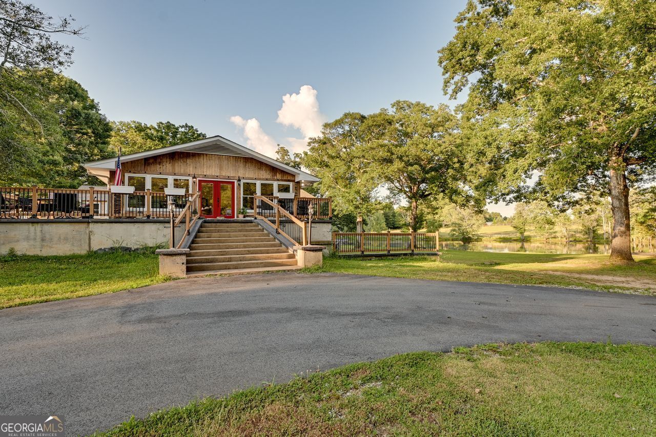25+ Acre Lakefront Equestrian Estate with Updated All-Brick Home! This beautifully updated all-brick home offers a huge country kitchen, tile bathrooms, premium 3/4" solid, had scraped, teak wood flooring, and two masonry fireplaces. Enjoy an architectural roof, fully finished basement, and an expansive sunroom with panoramic views of your own 5-acre stocked lake. The fully fenced acreage includes five separate pastures, a barn, and a stable with stalls and tack area-perfect for horses, livestock, or hobby farming. Heated and cooled detached garage and separate workshop provide the ideal space for projects, storage, or farm equipment, while the fully equipped commercial kitchen with prep area is ideal for catering, farm-to-table businesses, or homesteading ventures. Located just minutes from Covington Square and I-20, this private country estate offers the best of lakefront living, equestrian amenities, and acreage-all in a convenient location.