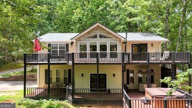 Welcome to this spacious and versatile 3-bedroom, 3-bathroom home located in the peaceful Sharp Top subdivision. Tucked away at the end of the road, this property offers rare privacy and a serene mountain setting that's perfect for full-time living, a weekend retreat, or a multi-family getaway. The main level features a comfortable and functional layout, including a master suite with a large walk-in closet and private bath, plus a guest bedroom and an additional full bathroom. The galley-style kitchen makes meal prep a breeze, and the two-sided fireplace adds a cozy charm as it connects both the great room and the dining area-perfect for gatherings or quiet evenings at home. Downstairs, the finished basement expands the living space with a third bedroom and full bath, a home gym or workout room, a spacious living area, and a second kitchen with a refrigerator, microwave, and sink (no range). It's an ideal setup for a separate living space, whether for a mother-in-law suite, guests, or even rental potential. You'll also find the main laundry room downstairs, but with laundry hookups available upstairs in the guest bathroom closet, convenience is built in. The basement also includes a one-car garage with extra storage space. Outdoor living is just as impressive, with two levels of decks to enjoy the mountain air and peaceful surroundings. The lower deck even features a hot tub for soaking and relaxing after a long day. Whether you're entertaining or unwinding, these outdoor spaces offer something for everyone. If you're looking for a quiet home in a private setting with room to spread out, this property checks all the boxes. Come see what mountain living is all about in Sharp Top!
