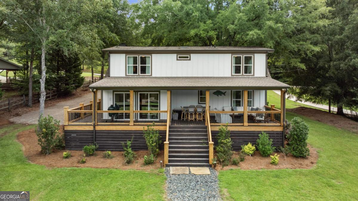 Your dream lake house is here-welcome to East River Bend! Set on a level waterfront lot in the heart of Lake Oconee, this stunning home has been completely renovated from top to bottom and feels brand new. The exterior shines with Hardie siding, cedar-trimmed columns, new doors and windows, and fresh landscaping with a cozy fire pit. A crushed slate pathway leads to the dock with cleats, lighting, and a seawall-perfect for enjoying life on the water. The expansive back deck, complete with stone accents and an extended covered porch, offers year-round outdoor living. Inside, the chef's kitchen impresses with a farmhouse sink, high-end appliances, custom cabinetry with leather pulls, a navy island, and a custom bar and pantry. Every bathroom has been updated with modern tile, vanities, and fixtures, while new flooring, trim, baseboards, lighting, and ceiling fans carry a fresh, stylish look throughout. Comfort is assured with a new water heater, HVAC systems, and ductwork. With space for a pool and or detached garage, easy access to local attractions by car or boat, and every upgrade already done, all that's left is to move in and start enjoying lake life!