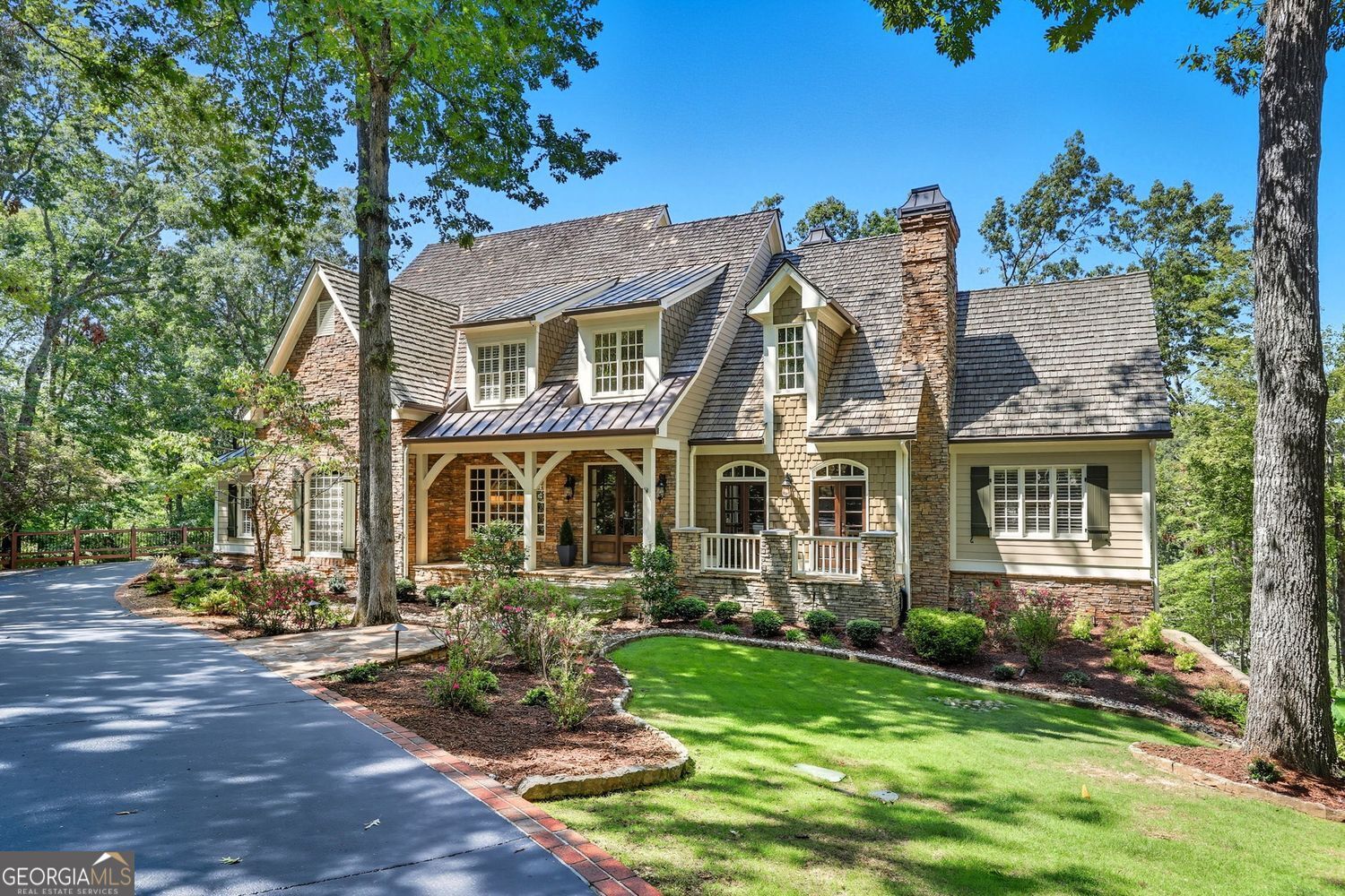Nestled on a private cul-de-sac, this custom-designed estate with a 4-car garage captures the perfect blend of luxury and timeless style. Overlooking the 13th and 14th fairways, the home offers breathtaking views of mature hardwoods within the prestigious Chestatee community, one of North Georgia's most sought-after neighborhoods, located on Lake Lanier. Step inside through the grand entryway into a sophisticated and stylish retreat featuring a library office with custom millwork, wood-beamed ceilings, and a cozy fireplace. Tall doorways, hardwood floors, and designer lighting create an atmosphere of elegance throughout the main level. The primary suite on the main floor is a serene escape with a spa-inspired bath, complete with a steam shower, heated floors, a beverage bar, and a custom closet. The great room impresses with its vaulted ceiling, two-story stone fireplace, and expansive woodland views. A chef's kitchen anchors the home with Thermador appliances including a professional range, integrated refrigerator/freezer, beverage center, coffee station, oversized island, and fireside keeping room with a soaring wood ceiling. Entertain effortlessly in the dining room with butler's pantry, or on the three screened porches and expansive deck. Upstairs, there are three spacious bedrooms each feature private baths and newer carpeting. The terrace level offers a full second kitchen, media room, game area, gym, bedroom, bathroom, and direct walkout to the gardens-perfect for entertaining or multi-generational living with access to the lower 2-car garage. Residents of Chestatee enjoy wonderful amenities: a Lodge, swimming pool, splash pad, tennis, pickleball and bocce ball courts, walking trails, parks, playgrounds and marina, as well as an abundance of social events throughout the year. The community also features the recently renovated Chestatee Golf Course and the Tee Time Tavern. Conveniently located near GA 400, University of North Georgia, medical facilities, Dahlonega, wineries and breweries. This home blends luxury with a relaxing lifestyle in an unparalleled setting.
