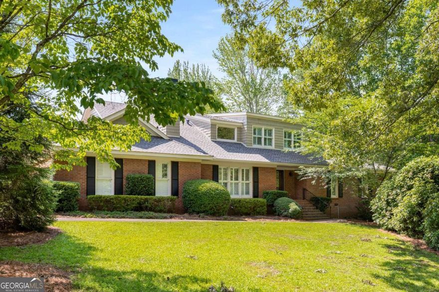 One of the most unique homes you will ever see, resting on nearly 2.5 acres of pristine beauty and located just 8 minutes from Marietta Square! This home has been meticulously maintained and improved featuring an indoor solar heated pool recently refinished, new hardwood flooring throughout most of the home, geothermal heating, solar panels for electric, updated primary bathroom with heated floors, massive primary walk-in closet, new septic tank, newer roof, renovated kitchen, large bonus room, detached apartment with a full kitchen/bath/living space, detached workshop with ample storage, and more. On the first floor you will love the open flow from the kitchen to the great room and dining room, 3 bedrooms (including the primary bedroom), lovely secondary family room that would make the perfect office, and a newer back deck that is both open air and a section attached to the primary bedroom that is screened, and space for a fitness center directly next to the indoor pool. Upstairs you will find an expansive bonus room that is perfect for a pool table and home theatre, with an additional bedroom and full bath that is the size of the primary bathroom. The recently updated back deck is a perfect place for your morning coffee, with a screened in section attached to the primary bedroom. There is a 2 car garage for the main home, with 3 additional garages in the backyard, and a spacious workshop. The detached apartment to the back of the property has a newly refinished kitchen and hardwood floors upstairs. The options for this property are endless! Come see the best that Marietta has to offer!