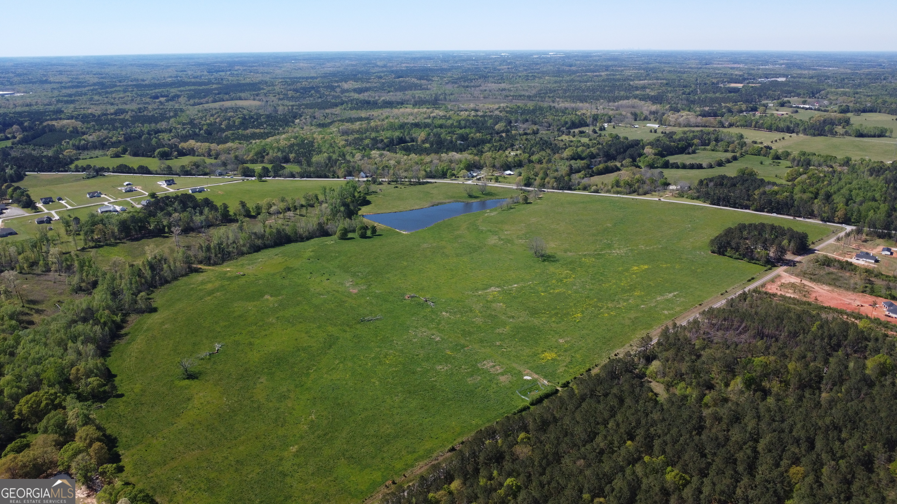 LAND FOR SALE - 131.08 Acres in Jackson, Butts Co. - A Rare Development Opportunity Nestled just outside the City of Jackson. There is a sprawling 131.08-acre breathtaking expanse of land, featuring a small lake, lush pastures, and expansive frontage along two major roadways. Whether you're an investor, developer, or visionary looking for the perfect blank canvas, this property offers exceptional potential. Prime Location & Accessibility * Unmatched Road Frontage: With a combined 5,266 feet of street frontage, this property provides significant visibility and accessibility. * Highway 16: 2,620 linear feet running east to west. * Barnes Road: 2,646 linear feet spanning north to south. Key Features & Highlights * Natural Beauty: Rolling pastures, minimal wooded areas, and a serene creek running along the left side and rear of the property. * Spring-Fed Pond: Located near Hwy 16, with approximate dimensions of 866 ft x 370 ft x 880 ft. * Ideal Proportions: The land forms an almost perfect square, optimizing development potential and efficient planning. * Level Terrain: Mostly cleared and ready for immediate use, ideal for residential subdivisions, commercial projects, or agricultural ventures. * Minimal Flood Risk: Zoned X, meaning low flood risk with a 500-year flood level, providing peace of mind for future construction. Endless Possibilities This property is more than just acreage; it's a strategic investment. Whether you're envisioning a new subdivision, a peaceful senior community, agricultural development, or commercial expansion, this land offers the space, infrastructure, and natural advantages to bring your vision to life. Don't miss this exceptional opportunity, explore the captivating pictures and video footage to see the full potential of this one-of-a-kind property!