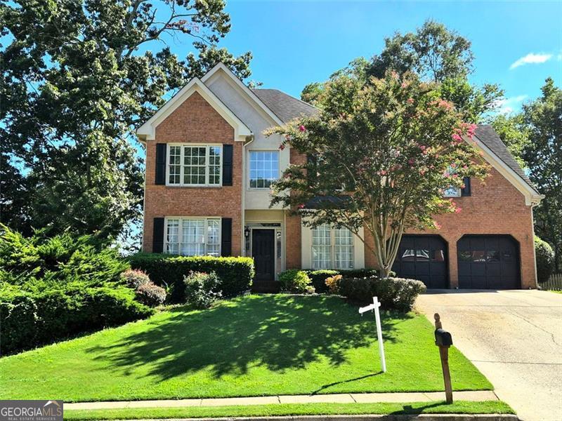 Stunning 6 bedroom, 3.5 bath home with a classic brick front, perfectly positioned on a private corner lot in the highly sought after Chandler Pond neighborhood and located in the Collins Hill School District one of Gwinnett County's top rated districts. Step into a grand two story foyer that opens to a bright and airy great room, filled with natural light and overlooking the expansive backyard. The well appointed kitchen features granite countertops, rich wood cabinetry, stainless steel appliances, and a peninsula with bar seating perfect for casual meals or entertaining. It flows seamlessly into a cozy breakfast nook and a spacious family room. The primary suite is a true retreat with vaulted ceilings, a large walk-in closet, dual vanities, a soaking tub, and a separate glass enclosed shower. The finished basement adds even more flexibility with a media room, home office, additional bedroom, and generous storage. Step outside to your own private oasis a large, fenced backyard with a multi-level deck, ideal for entertaining, grilling, or relaxing under the stars. Plus, an outdoor workshop offers the perfect space for tools, hobbies, or creative projects. Ready to close this August and just waiting for the right offer, this is an approved short sale priced below appraised value, seller's loss is your gain! Don't miss this rare opportunity to own a spacious, feature packed home at exceptional value. Chandler Pond residents enjoy fantastic amenities including a clubhouse, tennis courts, playground, and a scenic pond. Conveniently located near shopping, dining, Collins Hill Park, and top rated schools. Schedule your private tour today, this one won't last!