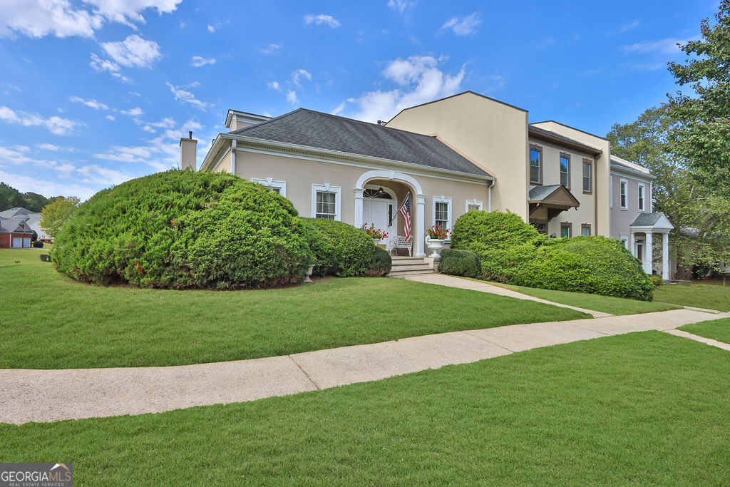 This spacious townhome is a fantastic opportunity for buyers looking to make it their own. With 3 bedrooms, 2.5 baths, and an upstairs flex space perfect for an office, playroom, or nursery, this home offers plenty of room for everyone. One of its standout features is the rare primary ensuite located on the main floor, which includes direct access to a covered, raised patio nestled in the highly sought-after Johns Creek area, this townhome is part of a unique subdivision that combines single-family homes with a select number of townhomes. It's ideally situated between the prestigious Atlantic Athletic Club and Country Club of the South, offering access to top-notch amenities, including excellent schools, a variety of restaurants, and shopping options. This end-unit townhome provides added privacy with a private alley leading to a detached, oversized two-car garage with pull-down attic storage, a feature offered by only a few homes in the development. The covered raised patio overlooks a generous fenced backyard, perfect for outdoor enjoyment. Inside, the main level is thoughtfully designed with plenty of square footage, including a living room, dining room, large eat-in kitchen, and a family room that opens to the patio. The main level also features a laundry room and a half bath, while the entryway and formal areas are highlighted by beautiful hardwood floors. Upstairs, you'll find two spacious bedrooms, a hall bath, and flex space, and a walk-in storage area. With low HOA fees that include swim and tennis amenities, this townhome is a rare find in a prime location.