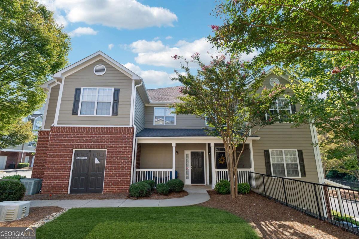 Welcome to your DREAM home nestled in the serene, gated Woodlands At Webb Bridge community. This beautifully updated condo sits in an unbeatable location, just steps from DOWNTOWN Alpharetta and AVALON. Enjoy upscale living at an affordable price in one of North Fulton's most sought-after neighborhoods! Thoughtful split-bedroom floor plan ensures privacy, with a PRIMARY suite featuring custom walk-in closets and romantic French doors opening to a private balcony. Newly installed hardwood-like floors, quartzite countertops, stylish backsplash, and stainless steel appliances create a sophisticated and inviting atmosphere. A NEWER HVAC unit and roof add peace of mind. The fireside family room flows seamlessly into an open-concept dining area and a sleek white kitchen with a breakfast bar, perfect for entertaining guests or COZY nights in. Savor morning coffee on the covered front porch or unwind on the PRIVATE balcony with tranquil wooded views. Additional storage off the patio keeps things organized. Enjoy GATED security, a clubhouse, sparkling pool, and pet-friendly walking paths, including a charming trail to Avalon. Perfect for those who love both city vibrancy and outdoor escapes. Includes a 1-car GARAGE, driveway, and ample unassigned parking spaces nearby for guests or roommates. Located just minutes from Avalon's upscale shopping, dining, and entertainment, and a short stroll to Downtown Alpharetta's vibrant farmer's market, concerts, and Alpha Loop trails, this condo offers the best of both worlds. Explore the nearby Greenway Trail for biking or hiking, or enjoy the quiet charm of this gated community with serene, wooded surroundings. With EASY access to GA-400, you're perfectly positioned for work or play. This meticulously maintained condo is move-in ready, offering affordable luxury with modern upgrades and low-maintenance living. Ideal for professionals, small families, or roommates, it's a rare opportunity to own in a prime Alpharetta location. Don't miss your chance to experience the perfect balance of urban excitement and suburban tranquility!