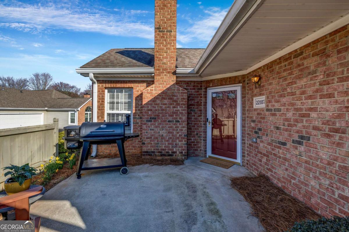 A Rare Opportunity for Stepless Living in the Heart of Johns Creek! Discover the perfect blend of comfort and convenience with this exceptional primary-on-main townhome, ideally located just minutes from restaurants, shopping, and parks. This vibrant community offers an abundance of amenities, including a saltwater pool, fitness center, library, outdoor patio, and clubhouse. Enjoy your own private patio, perfect for grilling and relaxing outdoors. Inside, the vaulted ceilings in the living room create an open and airy atmosphere, complemented by an abundance of natural light. The renovated kitchen features white cabinetry, stone countertops, ample prep space, and stainless-steel appliances. The home has been beautifully updated throughout, with engineered hardwood flooring on the main level. A spacious laundry room with built-in cabinetry adds extra storage. The second bedroom on the main level provides flexibility for guests, a home office, or a cozy den. Upstairs, a private guest suite boasts its own ensuite bathroom and a large walk-in closet ideal as a bonus or media room for added versatility. The low-maintenance lifestyle is made even easier with the HOA covering landscaping, water, sewer, trash, road maintenance, termite control, dwelling exterior, and common areas.
