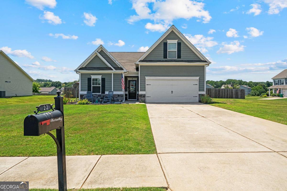 Nestled on a spacious corner lot in a serene Adairsville neighborhood, this well-maintained residence presents a thoughtful layout designed for contemporary living. The home's exterior is defined by its clean siding and a two-car garage, offering both a neat appearance and functional storage. The front yard provides a welcoming introduction, while the expansive backyard promises endless opportunities for outdoor enjoyment during the summer months. Upon entering, a sense of warmth and comfort greets you. The main level hosts the primary living areas, including a sizable great room with a fireplace, creating a focal point for gatherings. The open-concept design flows seamlessly into the kitchen and dining area, making it ideal for entertaining guests. The kitchen is equipped with granite countertops, stainless steel appliances, a pantry, and a large center island with seating, combining functionality with style. The primary suite, located on the main floor, is a private retreat with ample space for rest and relaxation. It features a trey ceiling, plush carpeting, and an ensuite bathroom with a spacious vanity area and a separate shower, providing a spa-like experience. Two additional bedrooms on the main level share a full bathroom, offering flexible accommodation options. Ascend the stairs to discover a generously sized fourth bedroom and a full bathroom, providing a private area perfect for older occupants, guests, or a dedicated home office. This bonus space offers versatility to adapt to your specific needs. The outdoor living space is a true highlight of this property. The backyard is a haven for summer activities, featuring a gazebo, providing a shaded retreat for outdoor dining or lounging. A stone fire pit area with seating is the perfect spot for evening gatherings and making memories under the stars. The fully fenced yard ensures privacy and a secure environment for outdoor play. This home offers a balance of comfort, style, and functional spaces, both inside and out. It is a place where you can truly settle in and enjoy the quiet life that Adairsville has to offer. Schedule your private tour today.