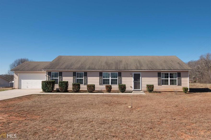 Welcome the spring in this beautiful country scenery. Great location-8 ½ miles to I-85, 3 miles to downtown Jefferson, and a convenient commute to Athens. Cute home located at the highest elevation of the subdivision. Flat and nice backyard of almost 3/4 of an acre. Ranch style with split floor plan-all in one floor! This home encompasses a foyer, living room, kitchen with stainless steel appliances, dining room, three bedrooms, two full bathrooms, newer foyer and living room hardwood floors (2015), wooden cabinets throughout, lots of closets, double pane windows, window screens, storm doors, blinds, 2-car garage (no sheetrock), and patio. Hardie plank type siding construction. $1,500 CONTRIBUTION from Preferred Lender Toward Closing Costs. It may be winter, but Jefferson’s real estate feels like 105 degrees! This affordable home won't last too many days on this market. Call today for a showing.