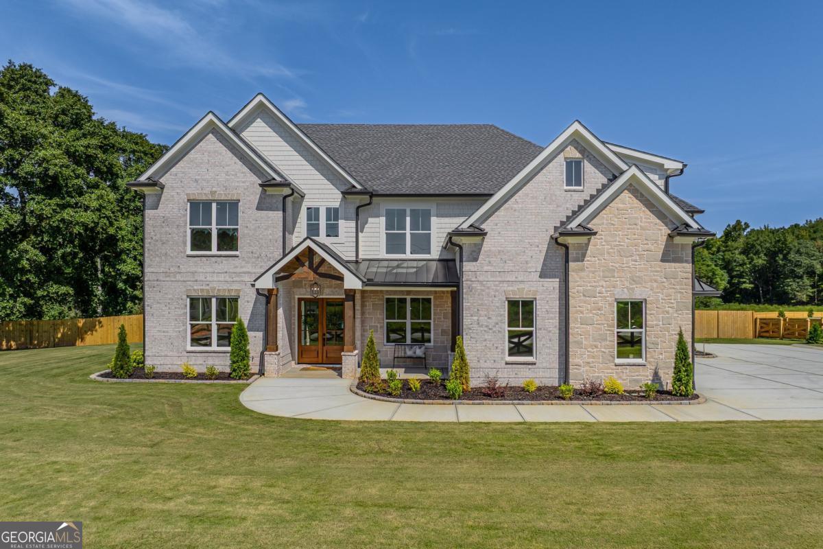Why wait to build when this designer-crafted estate in Dacula is ready to welcome you home? Perfectly positioned on a private, level lot, this move-in ready masterpiece redefines luxury living with a floor plan that is both functional and unforgettable. With 5 spacious bedrooms-including dual primary suites, one on the main level and another upstairs-you'll find unmatched flexibility for hosting guests, multi-generational living, or simply enjoying added comfort. Each primary suite offers a spa-worthy en suite bath and jaw-dropping boutique-style walk-in closets. Even the secondary bedrooms were designed with intention, offering generous size, custom details, and access to thoughtfully appointed bathrooms. Upstairs, you'll also find not just one, but two bonus spaces: a dedicated media/bonus room for movie nights or game days, plus an additional bonus room perfect for a playroom, home gym, or flexible living space. At the heart of the home, the chef's kitchen makes an undeniable statement with its expansive island, custom cabinetry, and light-filled breakfast nook. A hidden prep kitchen, complete with its own stove, pantry, and sink, keeps the main space flawless for entertaining. Wide-plank hardwood floors flow throughout, complemented by incredible high-end trim and millwork that showcase craftsmanship at its finest. Designer lighting adds depth and drama, enhancing every room with a curated finish. For gatherings, the formal dining room comfortably seats 12+, while the dedicated home office ensures a polished space for work. Step outside to your private resort-style oasis: a sparkling heated pool with mood-enhancing, color-changing lights, a waterfall spa, and an oversized covered patio ideal for sunset dinners, relaxed weekends, and unforgettable celebrations. With a 3-car garage, abundant storage, and exceptional design at every turn, this home stands apart from the rest. While new construction is everywhere, nothing compares to this residence-built with intention, elevated with style, and finished with the details that truly matter. This is luxury living, perfected.