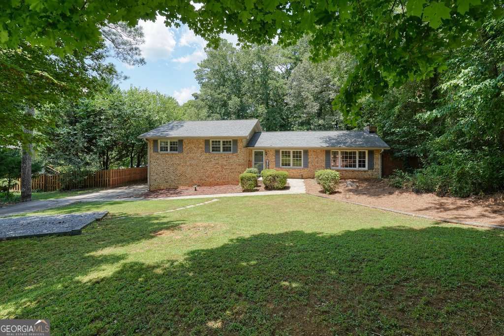 Discover classic charm and modern potential in this 4-sides brick ranch, perfectly situated on almost an acre just minutes from vibrant Downtown Woodstock. Built in 1973, this well-maintained 3-bedroom, 2-bath home offers beautiful hardwood floors, a bright and freshly painted interior, and a cozy brick fireplace for relaxing evenings at home. The partial finished basement includes a third full bathroom that's ready for your finishing touches - perfect for expanding your living space or adding a guest suite. Step outside to your private, fenced backyard complete with a firepit - ideal for entertaining or unwinding under the stars. Recent updates provide peace of mind: new interior HVAC system, new water heater, fully encapsulated crawlspace, and a recently serviced septic tank. Enjoy incredible access to the upcoming Noonday Creek Trail extension, which will connect Downtown Woodstock to Noonday Creek Park and beyond - ride your bike all the way to the Silver Comet Trail and into Alabama without ever leaving a paved path! With its unbeatable location less than 5 minutes to Downtown Woodstock's shops, dining, and entertainment, this home is move-in ready and waiting for your personal touch. Don't miss this rare opportunity!