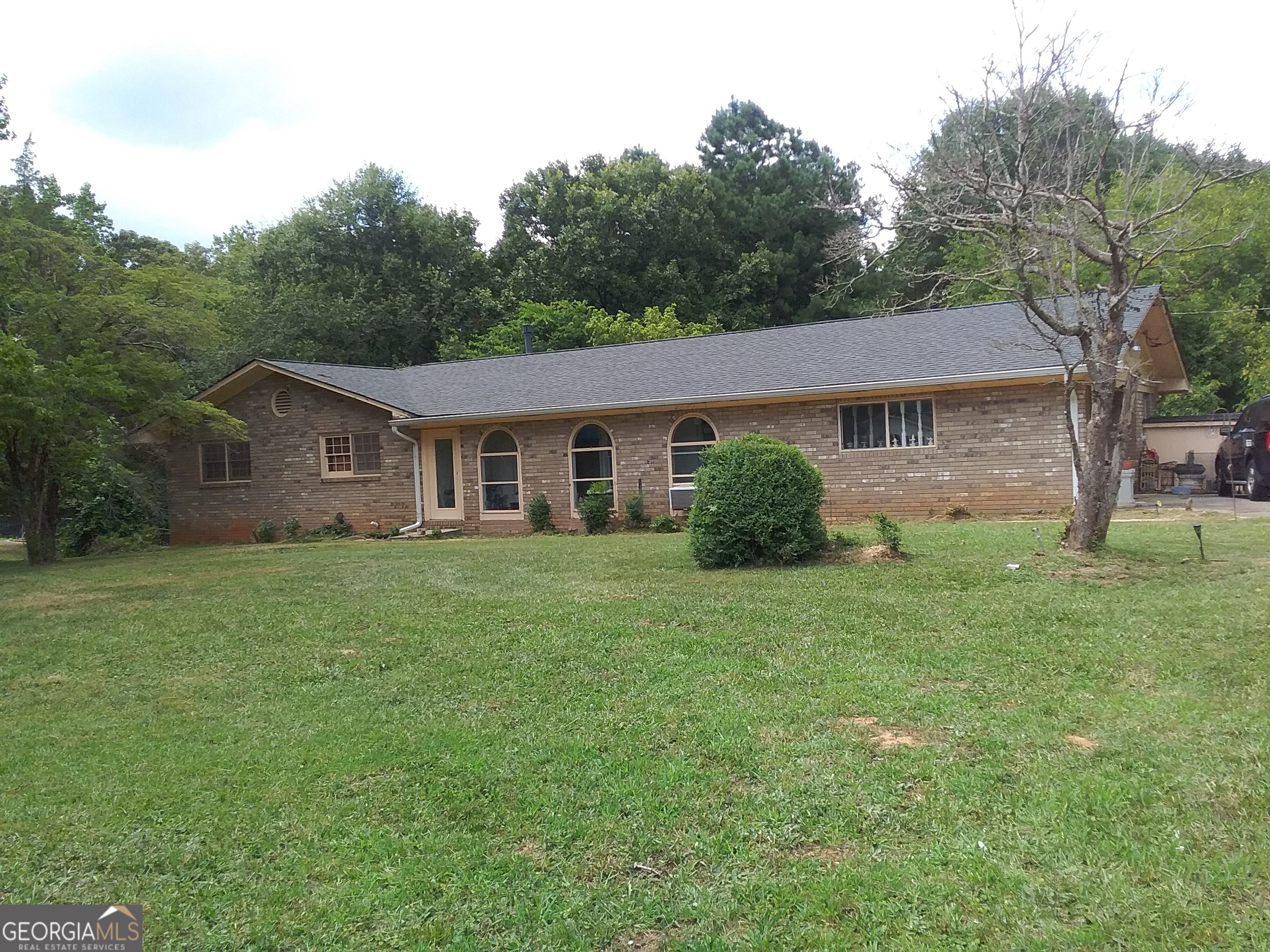This 3 BR/2 BA Brick ranch is on a 1.00 Acre Lot with a full unfinished basement. The sunroom enters from the parking pad and an additional bonus room is off the family room. The area is in close proximity to the Wolf Creek golf course, entertainment center and library, Campcreek Marketplace, the Atlanta airport and easy access to major highways.