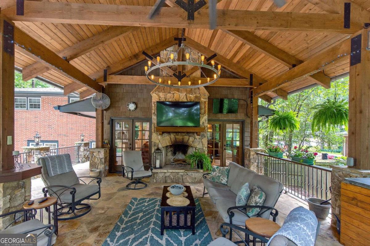 Welcome to this beautifully maintained home in the ever-popular Briarmoor Manor neighborhood. Set on a little over .50 acre of landscaped grounds with four season blooms, this property is designed for comfort, entertaining, and everyday living. The flexible first-level suite offers a spacious bedroom with walk-in closet and en-suite bath-ideal as a primary retreat or private guest quarters. A large laundry room is also conveniently located on this level. The main floor features a light-filled living room, dining room, updated kitchen, powder room, and a generous fireside family room perfect for gatherings. Upstairs you'll find three additional bedrooms and a generously sized bath. The true highlight of this home is the incredible outdoor living space. A commercial-grade "mountain lodge" porch off of the fireside family room boasts soaring 16-foot ceilings, a stone fireplace, three zones of lighting, dual TV setup, and a full outdoor kitchen complete with a 6-burner Napoleon Professional natural gas grill, side burner, wine fridge, and natural gas heater-just in time for football season. A 6-person Jacuzzi hot tub with UV filtration system adds year-round relaxation, while the 10x10 playhouse and expansive parking for 10+ vehicles (or RV) make entertaining easy. Additional features include a large woodworking workshop with 20Amp and 220V sub panel, encapsulated crawl space with dehumidifier, and double-pane windows throughout. Briarmoor Manor offers a neighborhood pool with a swim team, and the location provides quick access to I-85, I-285, Emory, CDC, Oak Grove Village shops, restaurants, and parks. This home blends space, function, and lifestyle-ready to welcome its next owners.