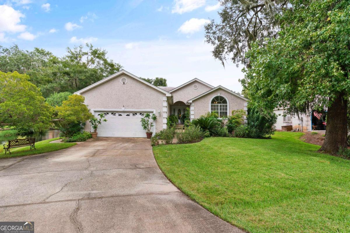Located in the charming community of Sea Palms West, this delightful tabby, ranch-style 3 bedroom, 2 bathroom home offers a serene lifestyle with its picturesque lagoon views. The property boasts newly installed hardwood floors creating a warm and inviting atmosphere. The spacious living room, complete with a gas fireplace, provides the perfect setting for relaxation and entertainment. The home has a large kitchen, featuring ample counter space and modern appliances, including a new KitchenAid convection oven and microwave. Adjacent to the kitchen, a breakfast area offers stunning views of the lagoon, making every meal a visual treat. For more formal occasions, a separate dining room is available. The large master bedroom has vaulted ceilings and his and her walk in closets. The ensuite bathroom boasts dual vanities and separate shower and tub facilities for ultimate convenience. Nature enthusiasts will appreciate the screened porch, offering a bug-free outdoor living space to enjoy the surrounding wildlife. The property sits on a generous corner lot, providing privacy and space for outdoor activities. As part of the Sea Palms West community, residents have access to an expansive 50-acre greenspace, perfect for walking, biking, and enjoying the outdoors. Additional features include ample storage throughout the home, ensuring a clutter-free living environment. The property's location near local amenities such as schools, parks, and shopping centers adds to its appeal, making it an ideal choice for those seeking a balanced lifestyle in a beautiful coastal setting. https://youtu.be/mHfEntsU5ls