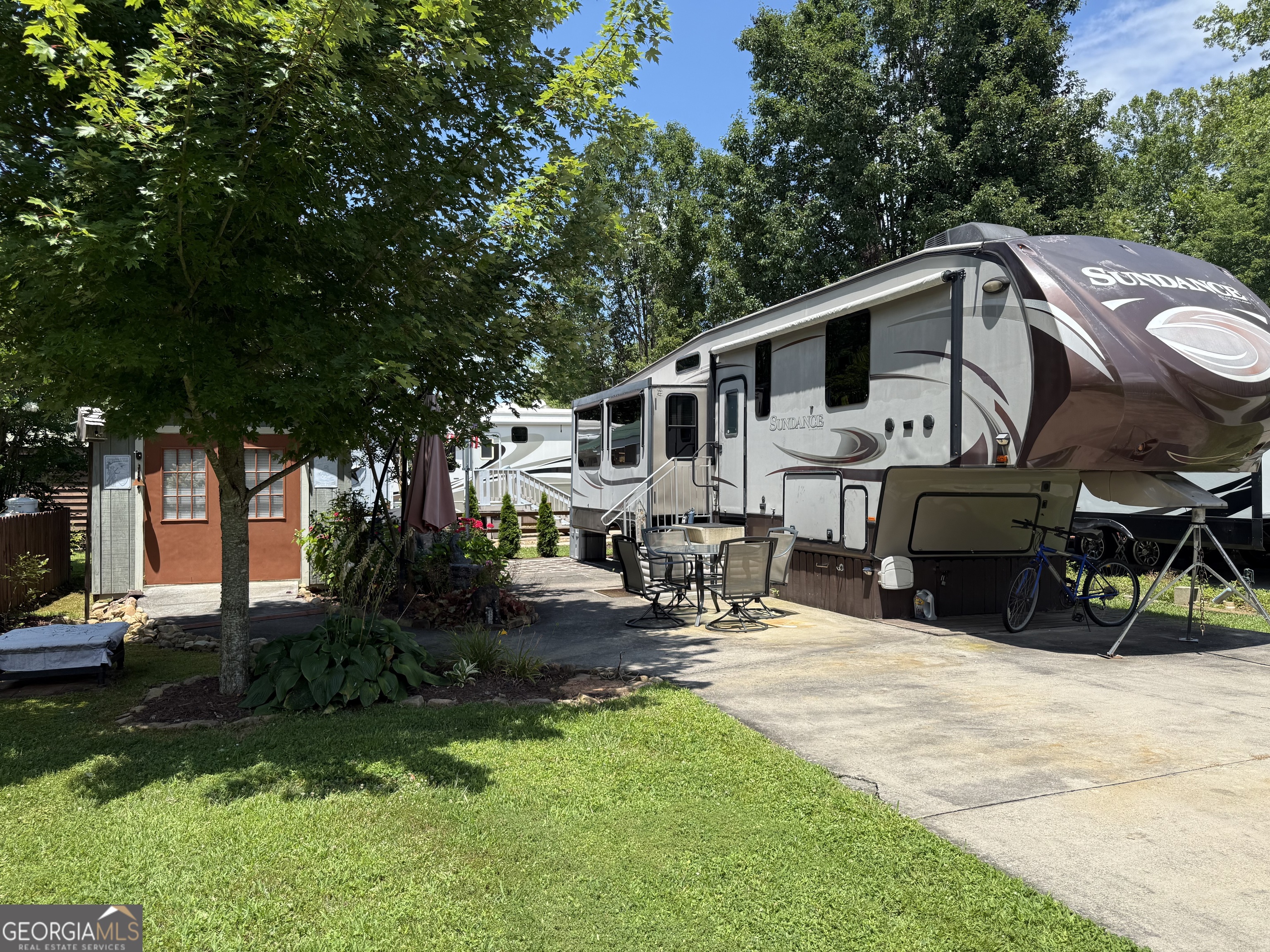 Mountain living at it's Best! Enjoy full-time or part-time living on this perfectly situated lot in the popular Rivers Edge RV Park. Relax and enjoy the serene environment in the 2013 Sundance 3380RL 5th Wheel RV. Nice detached building that is great for storage and includes washer&dryer. Park amenities include a large pavilion with laundry facilities, a huge rocking chair porch overlooking the pond and many seasonal social events. This is the perfect time to purchase and enjoy your time in the mountains! Call us today!