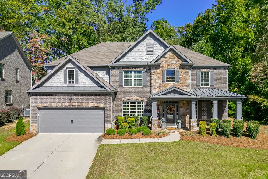 Meticulously maintained 5-bedroom, 4-bath home located in the award-winning Buford City School District. Nestled on a stunning private lot, this home showcases beautiful custom trim, hardwood flooring on the main level and custom millwork features adding warmth and sophistication to every space. The open-concept floor plan offers endless options for everyday living and entertaining. The kitchen is a cook's dream, featuring top-notch appliances, double ovens, and abundant counter and cabinet space. A keeping room with a second fireplace provides a cozy retreat, while the butler's pantry and custom mudroom blend function with style. The living room boasts a stunning floor to ceiling window wall, beautiful stacked stone fireplace and custom benches and shelving.  The dining room is a true stunner with coffered ceiling, window box trim, crown molding & beautiful natural light.  Don't miss the bedroom on the main level for additional sleep space, home office or playroom.  Upstairs, the owner's suite is a true escape with a large sitting area and spa-inspired ensuite bath. There are 3 additional large bedrooms all with private access to a bathroom and the amazing laundry room with sink!! Outside, enjoy an entertainer's DREAM backyard complete with a covered patio, built-in Blackstone griddle and smoker, and plenty of space to gather. Conveniently located in the desirable Whispering Creeks community, within walking distance to Buford High School and the Buford Community Center, this home truly has it ALL!